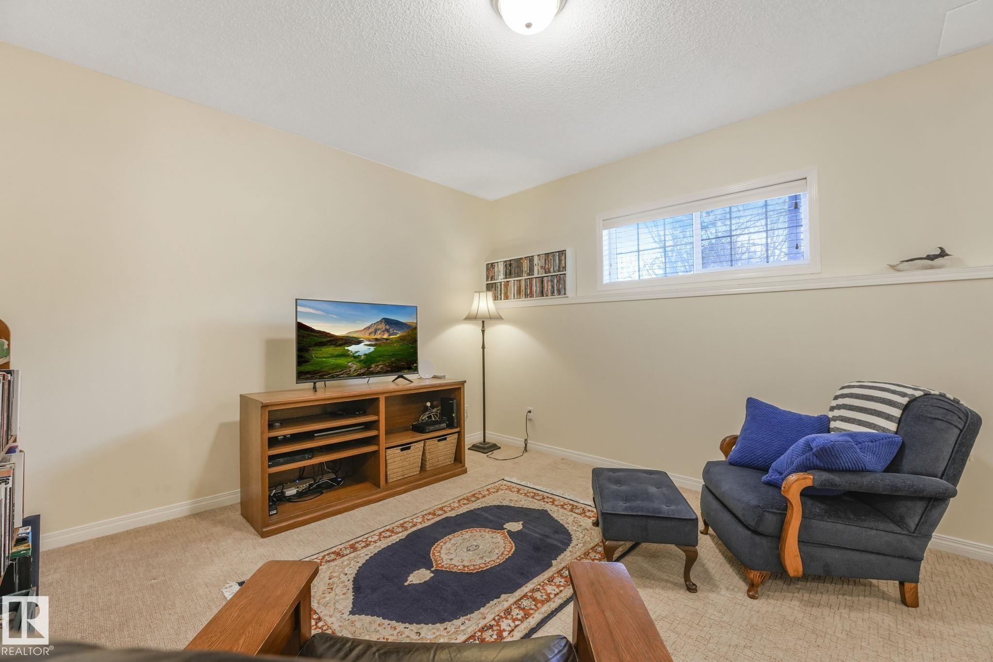 Living room featuring carpet and a textured ceiling - 23 4755 Terwillegar Common, Edmonton, AB - Indoor