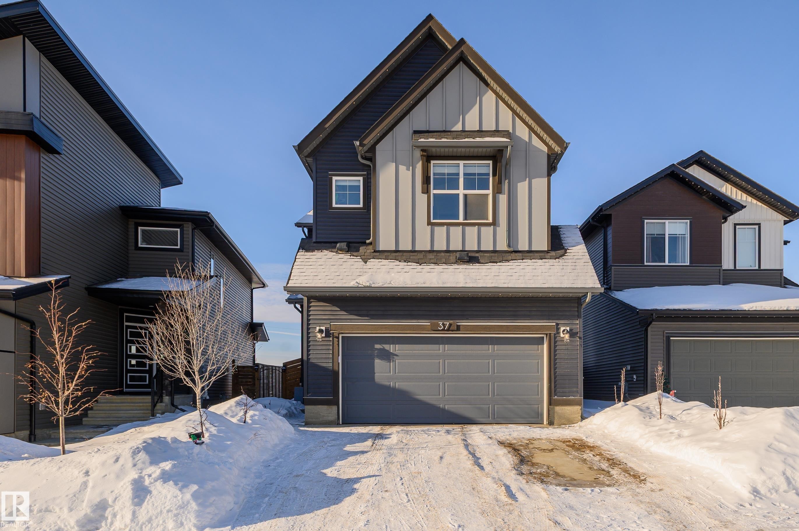 View of front of home with board and batten siding and a garage - 37 Rhea Crescent, St. Albert, AB - Outdoor With Facade