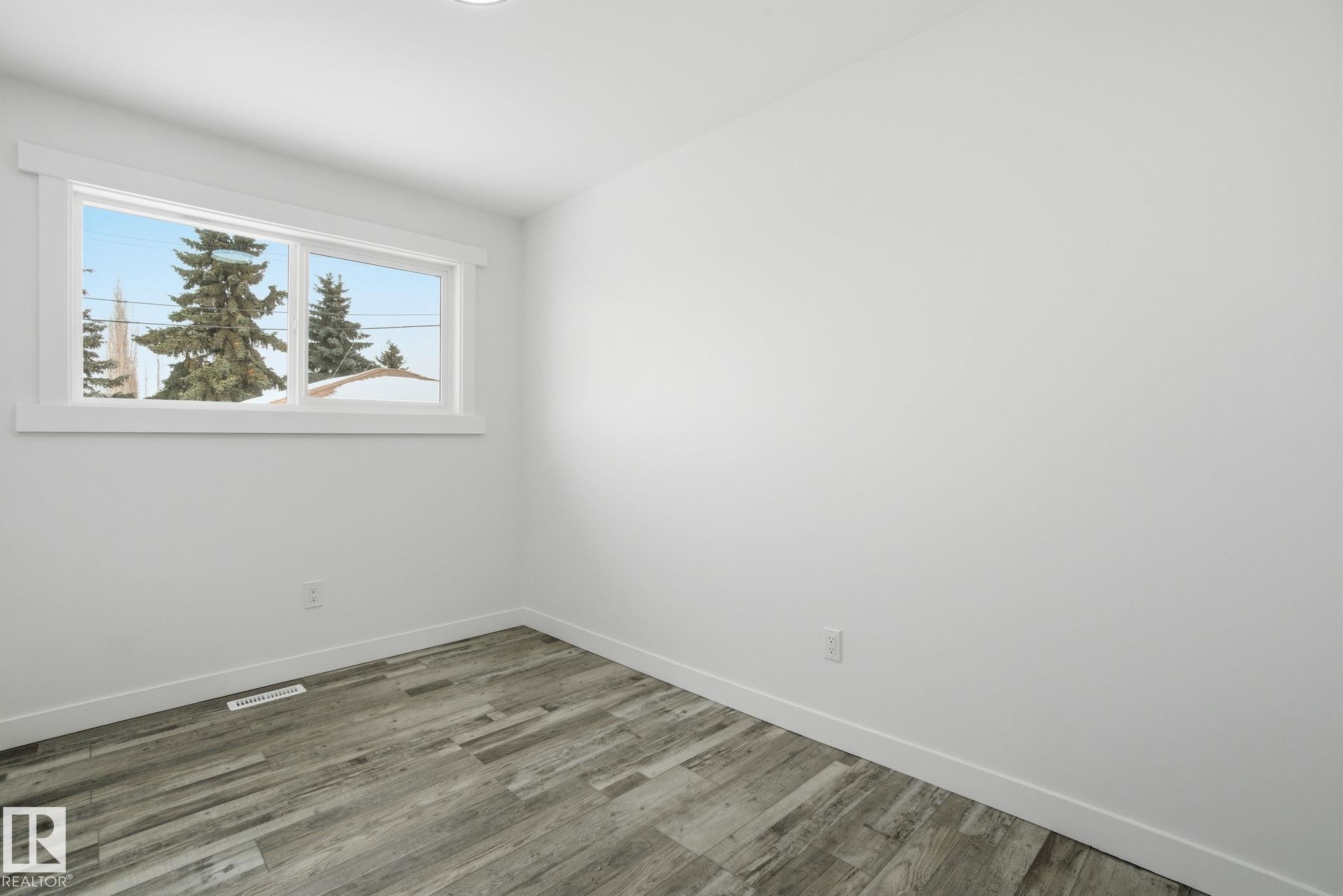 Empty room with wood finished floors and baseboards - 7112 132 Avenue, Edmonton, AB - Indoor Photo Showing Other Room