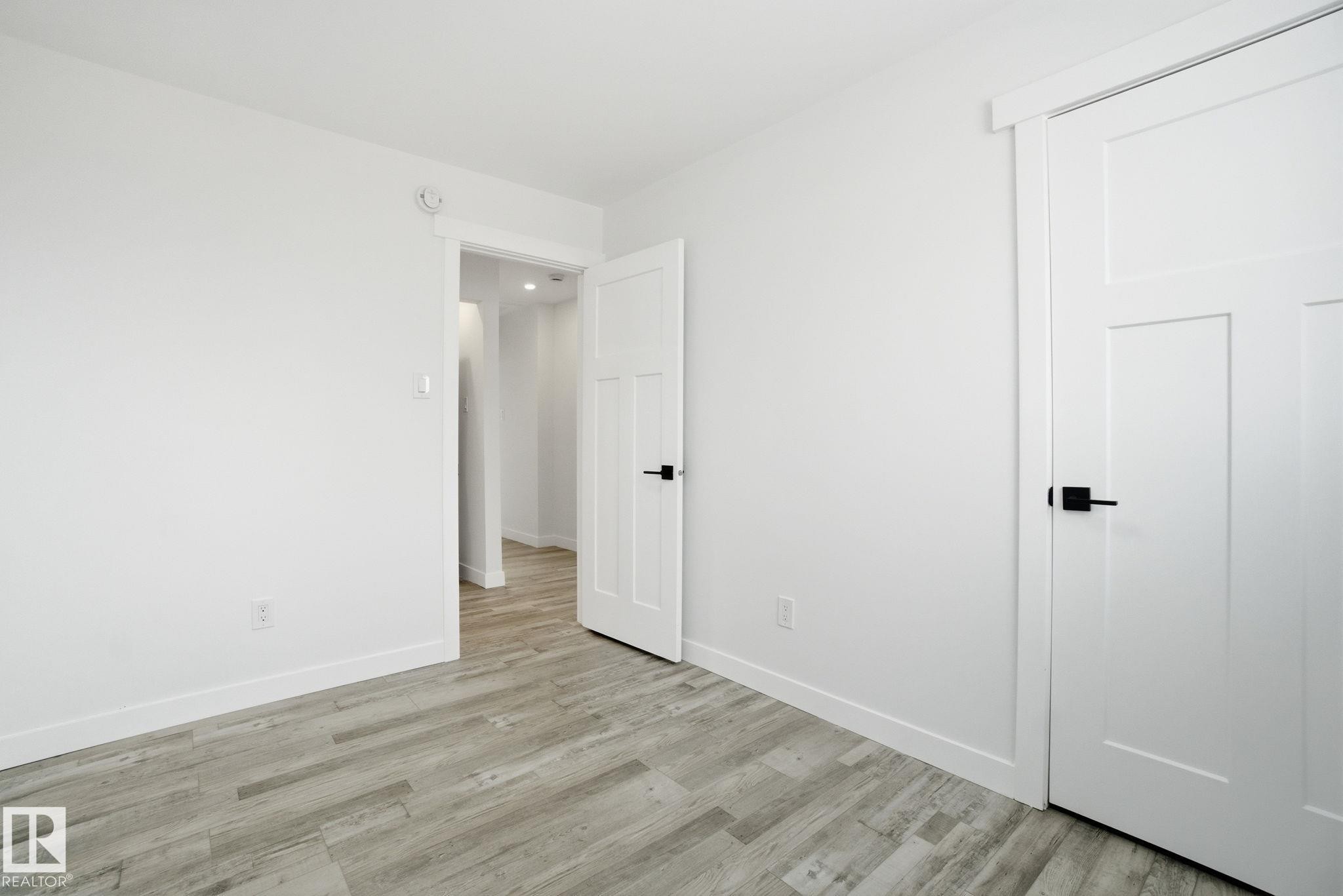 Unfurnished bedroom with light wood-type flooring and baseboards - 7112 132 Avenue, Edmonton, AB - Indoor Photo Showing Other Room