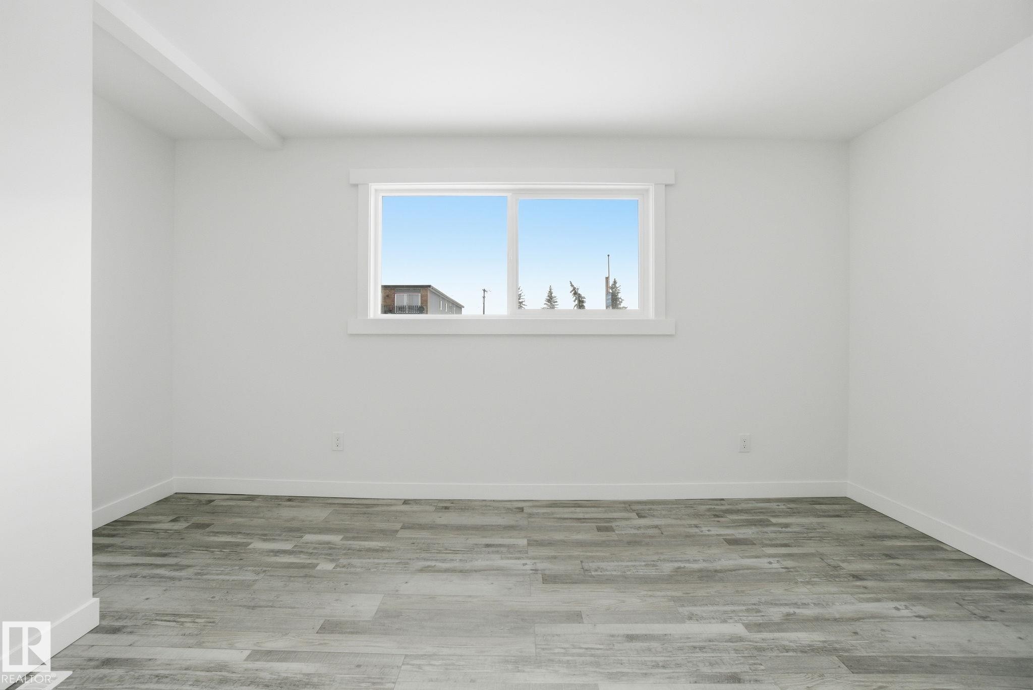 Empty room with light wood finished floors - 7112 132 Avenue, Edmonton, AB - Indoor Photo Showing Other Room