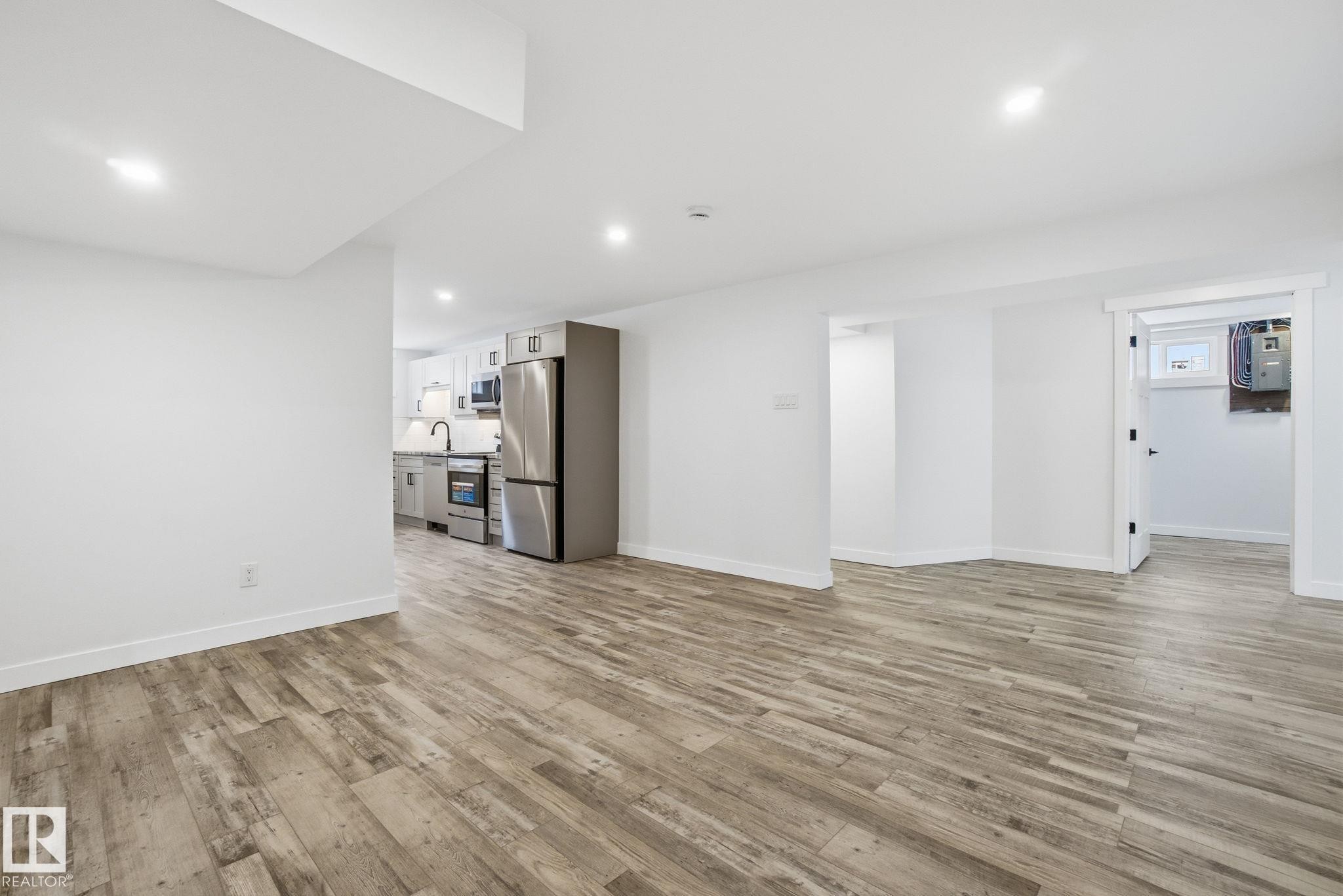 Unfurnished living room with light wood-style flooring and recessed lighting - 7112 132 Avenue, Edmonton, AB - Indoor Photo Showing Other Room