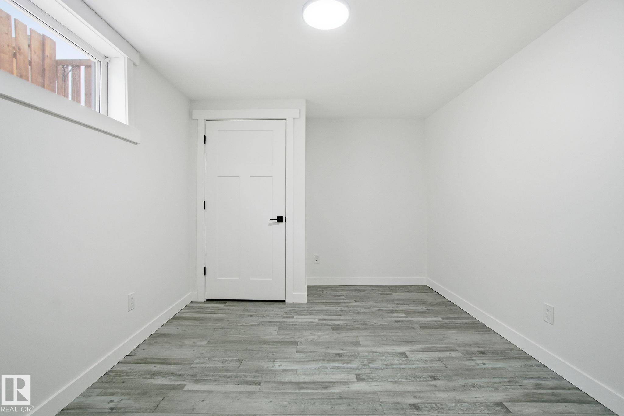 Unfurnished room with light wood-style flooring and baseboards - 7112 132 Avenue, Edmonton, AB - Indoor Photo Showing Other Room