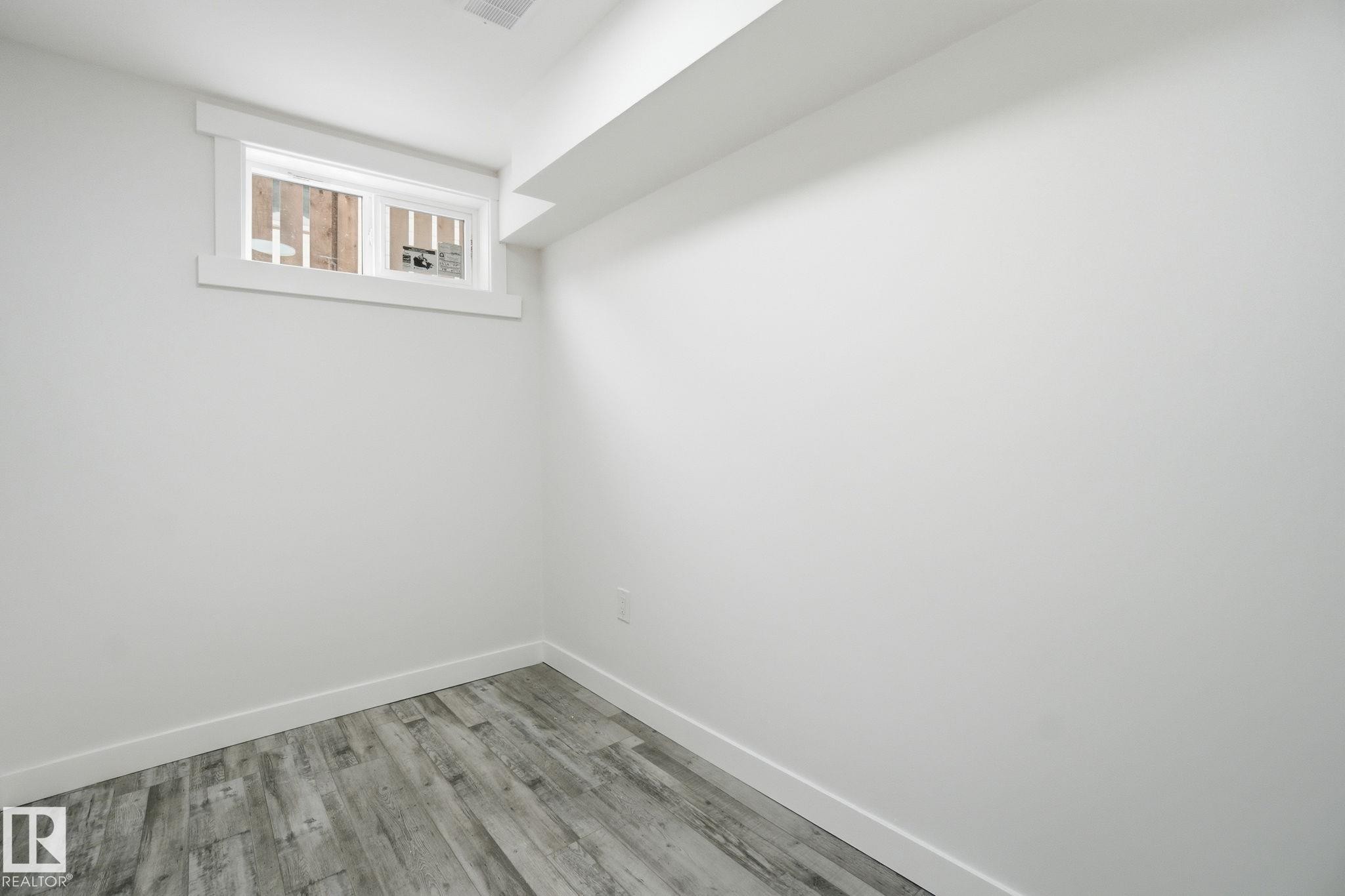 Unfurnished room with baseboards and wood finished floors - 7112 132 Avenue, Edmonton, AB - Indoor Photo Showing Other Room