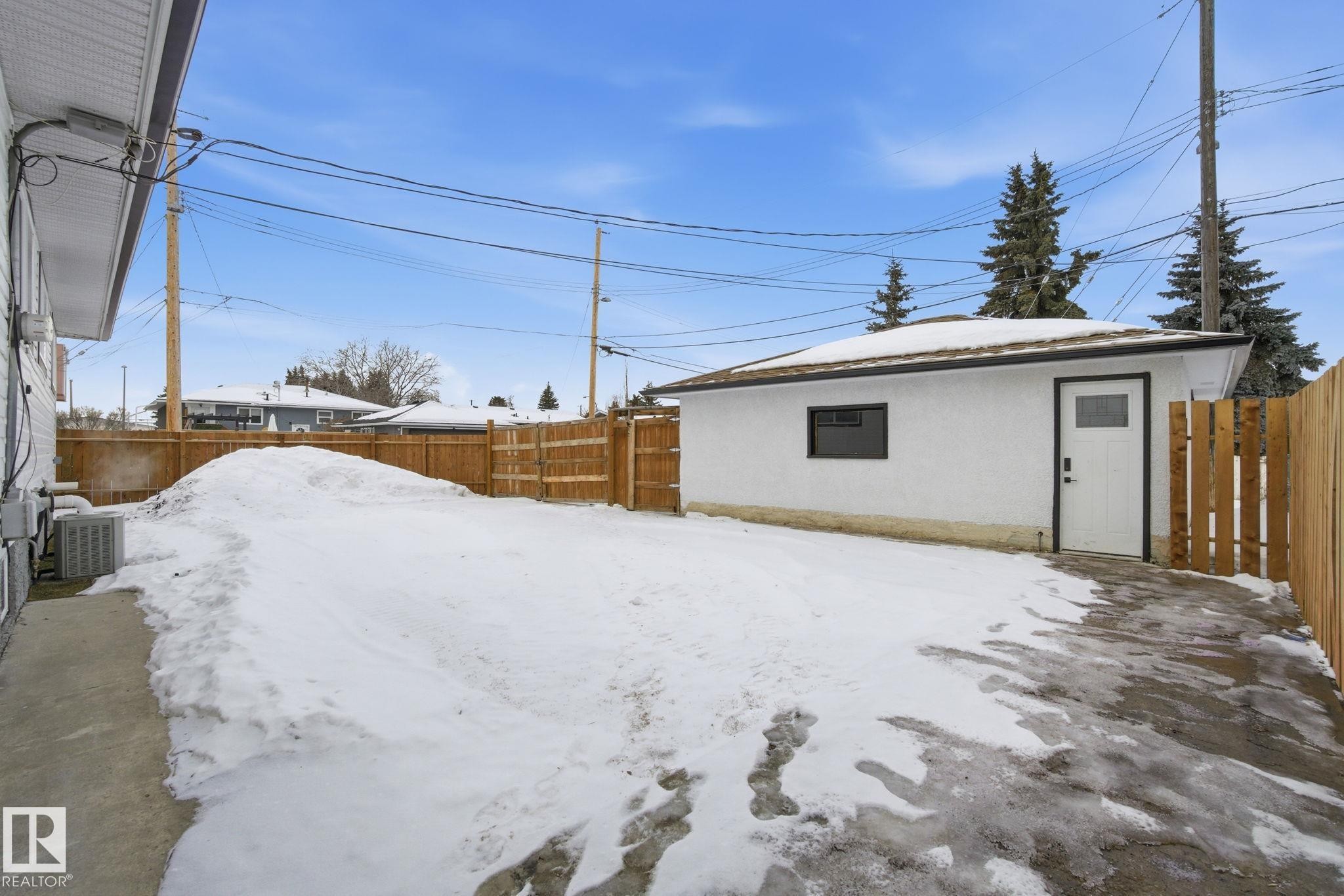 Yard covered in snow featuring a fenced backyard and an outdoor structure - 7112 132 Avenue, Edmonton, AB - Outdoor