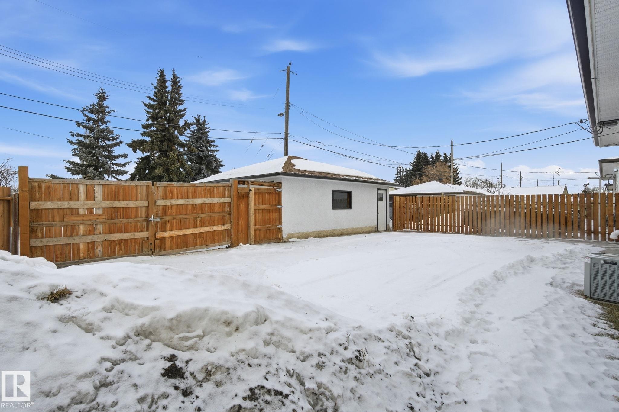 Snowy yard featuring a fenced backyard and a gate - 7112 132 Avenue, Edmonton, AB - Outdoor