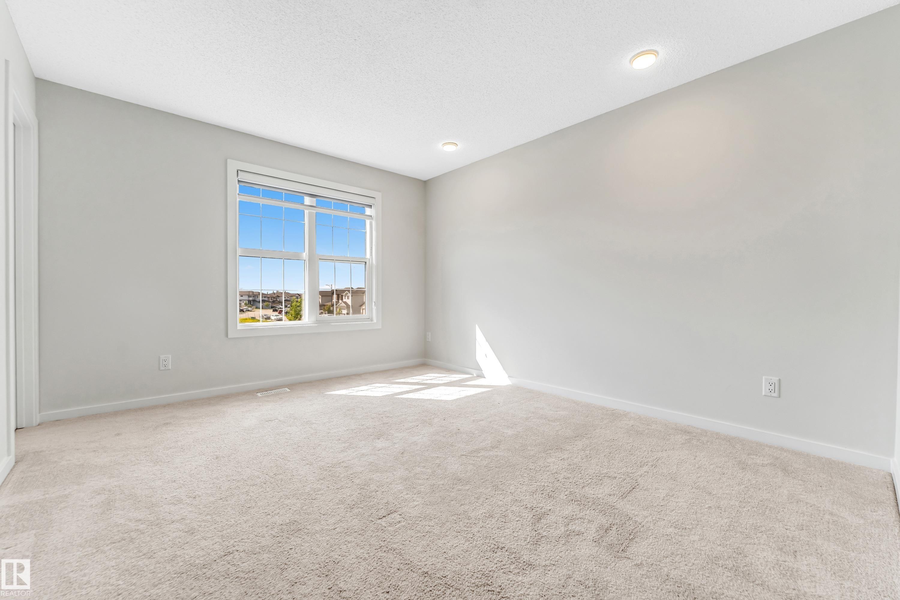 Spare room with light colored carpet and a textured ceiling - 2095 Maple Road, Edmonton, AB - Indoor Photo Showing Other Room