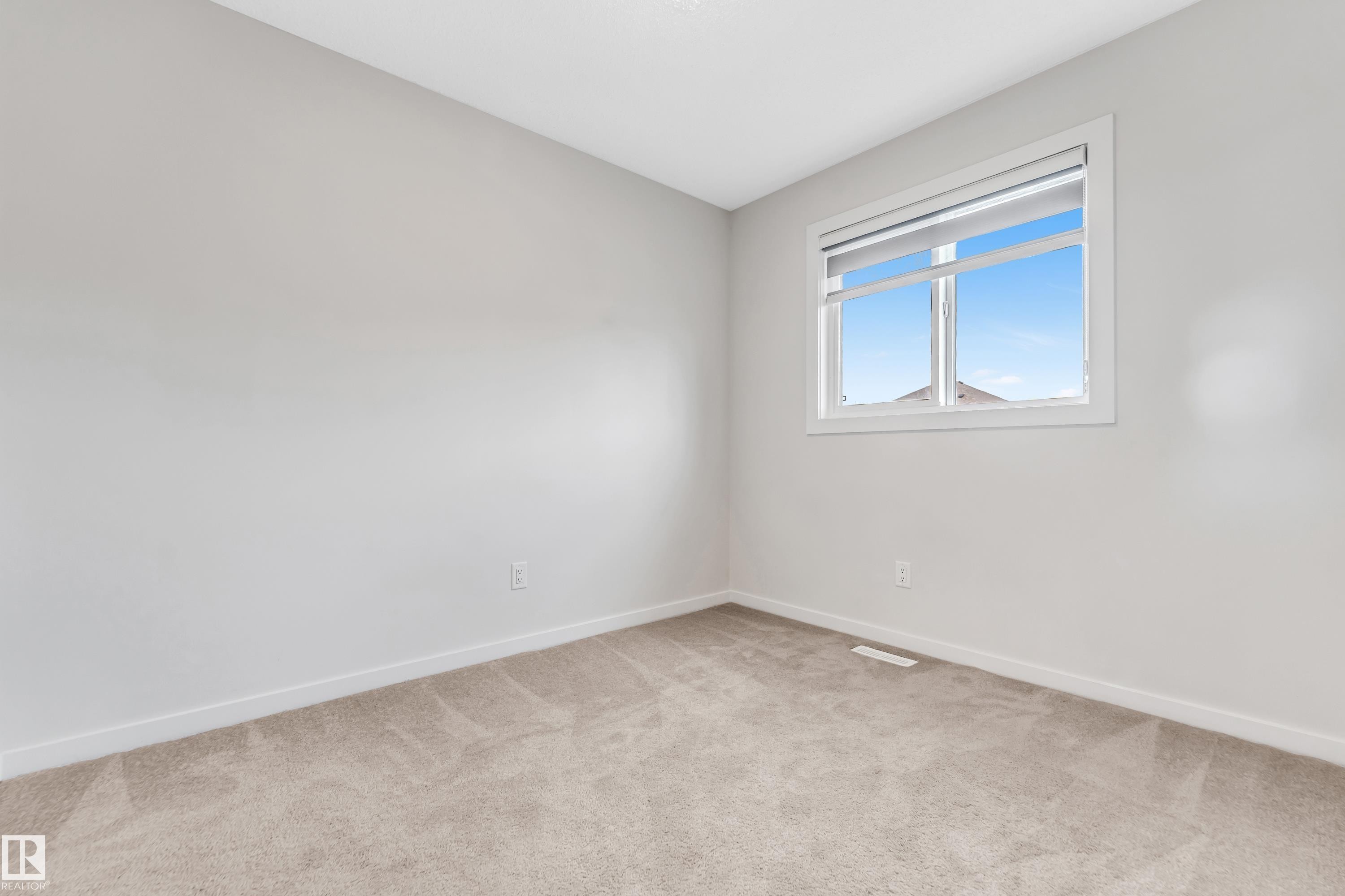 Spare room featuring baseboards and light carpet - 2095 Maple Road, Edmonton, AB - Indoor Photo Showing Other Room