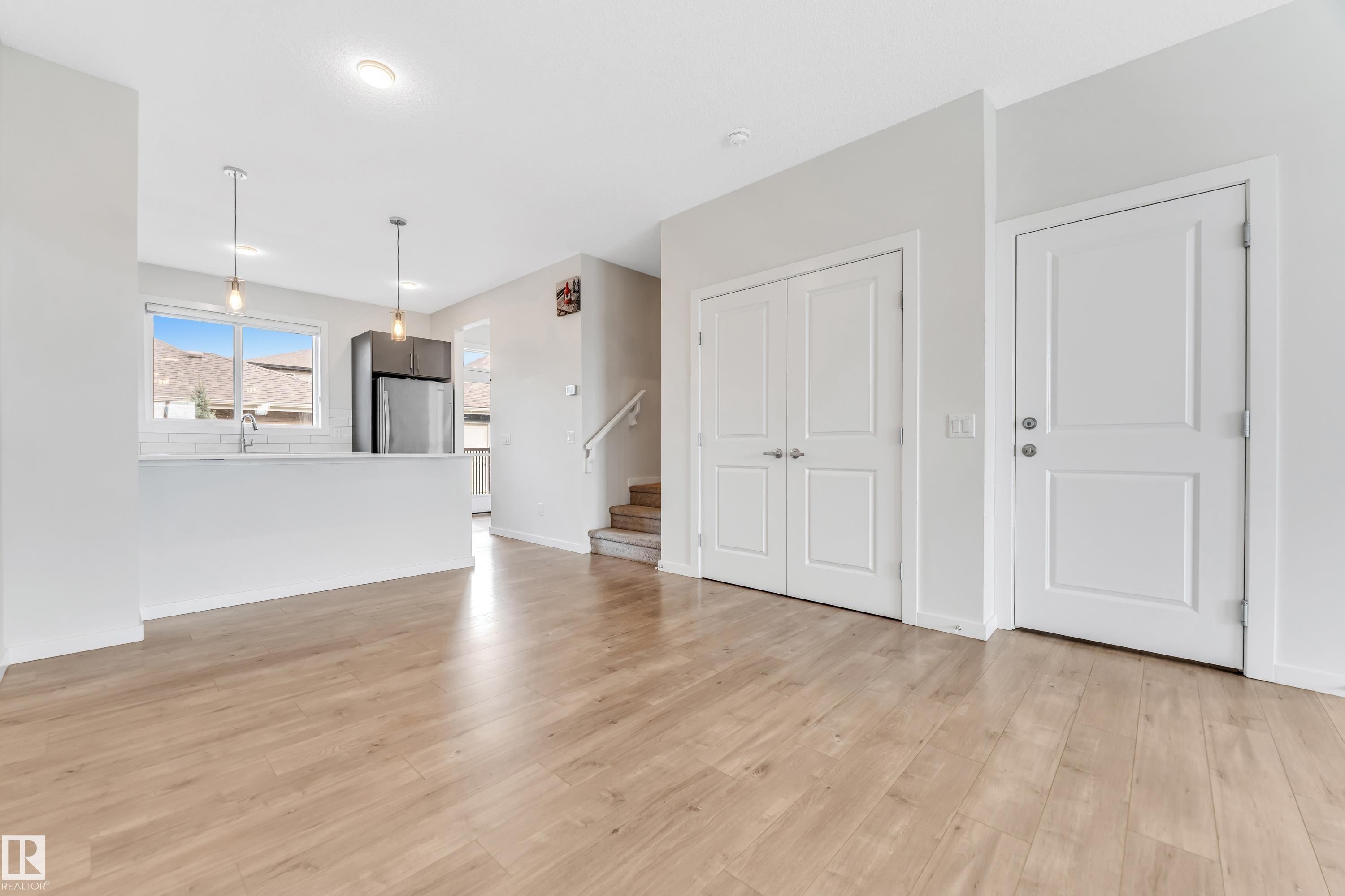 Unfurnished living room with stairway and light wood-type flooring - 2095 Maple Road, Edmonton, AB - Indoor