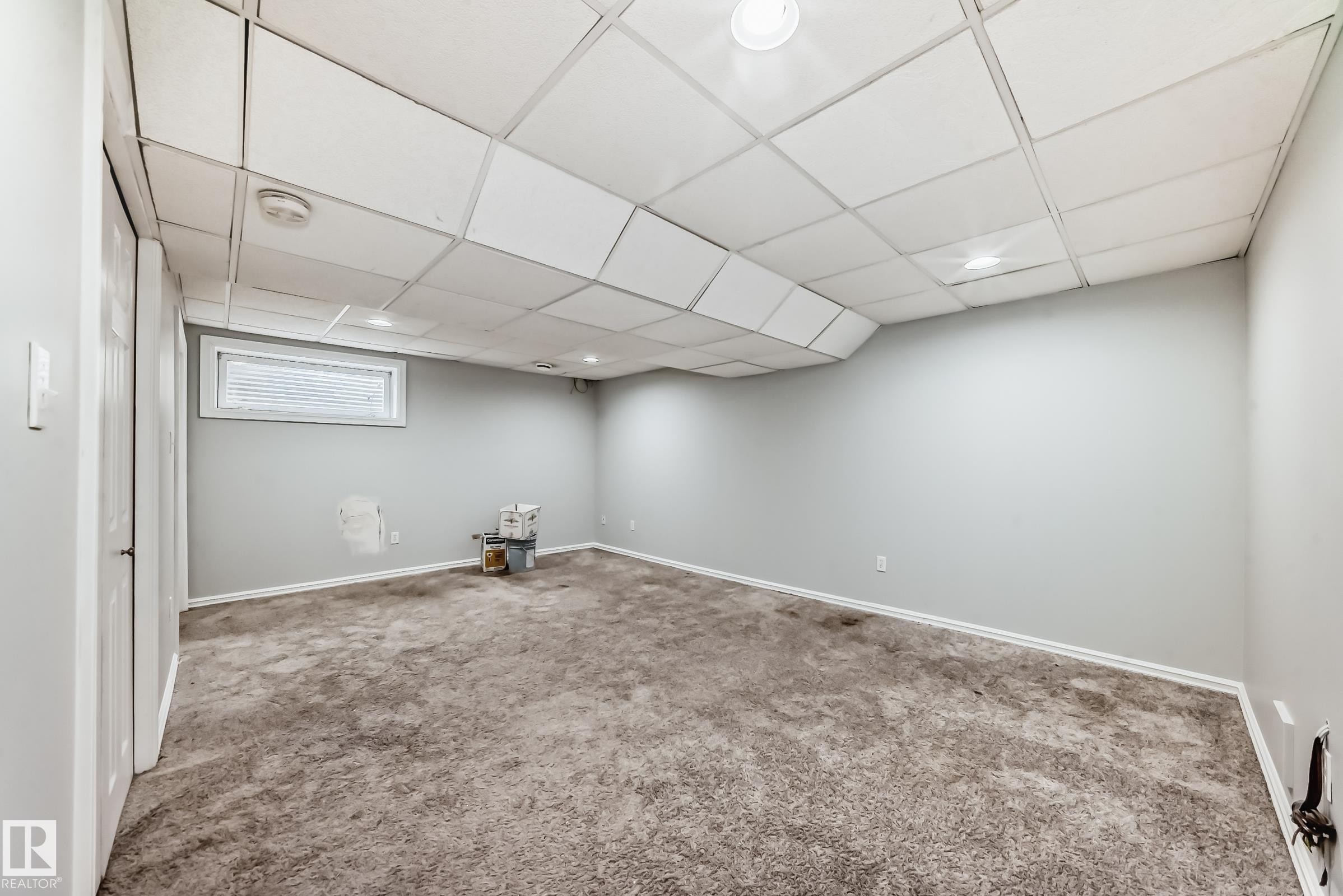 Basement featuring a paneled ceiling and carpet flooring - 7731 8 Avenue, Edmonton, AB - Indoor
