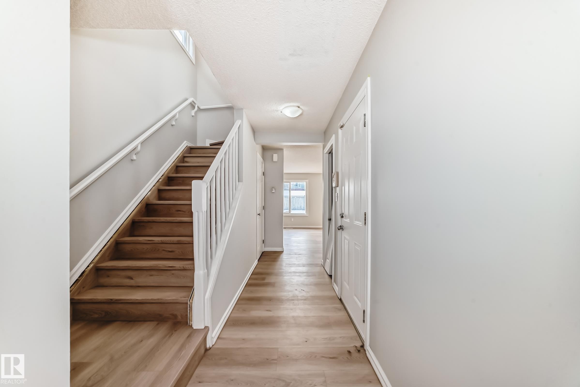 Staircase featuring baseboards and wood finished floors - 7731 8 Avenue, Edmonton, AB - Indoor Photo Showing Other Room