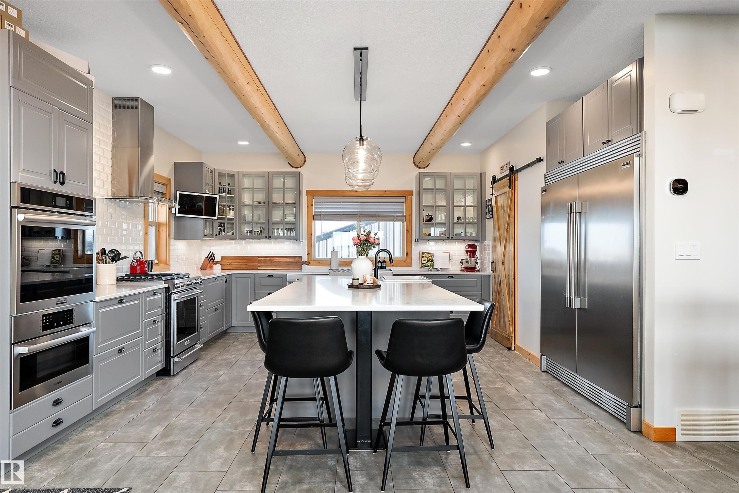 Kitchen featuring gray cabinetry, a barn door, decorative backsplash, beamed ceiling, and recessed lighting - 19003 Twp Rd 522, Rural Beaver County, AB - Indoor Photo Showing Kitchen With Upgraded Kitchen
