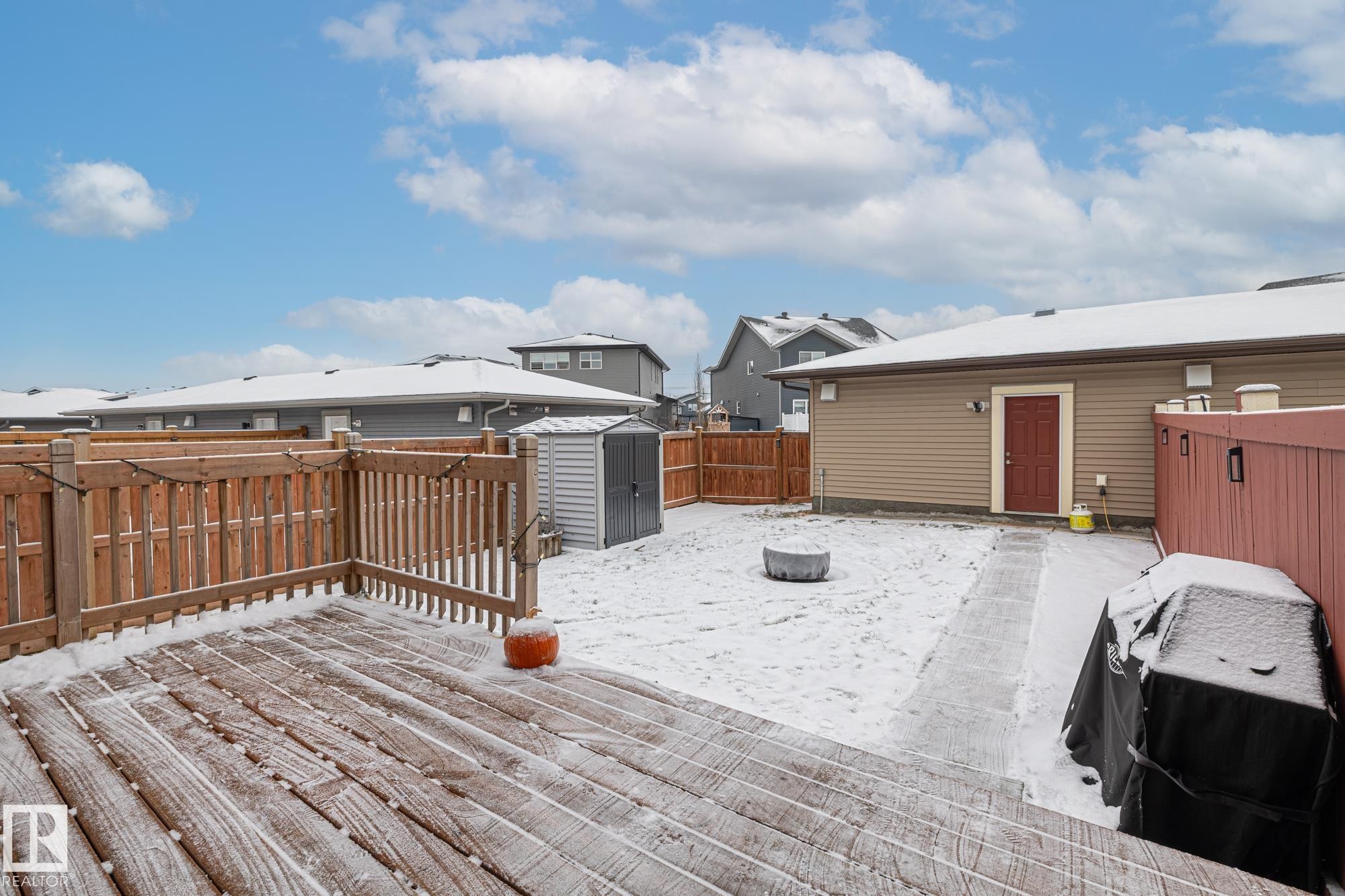 Snow covered deck with a storage shed, a fenced backyard, and an outdoor fire pit - 20110 27 Avenue, Edmonton, AB - Outdoor With Deck Patio Veranda With Exterior