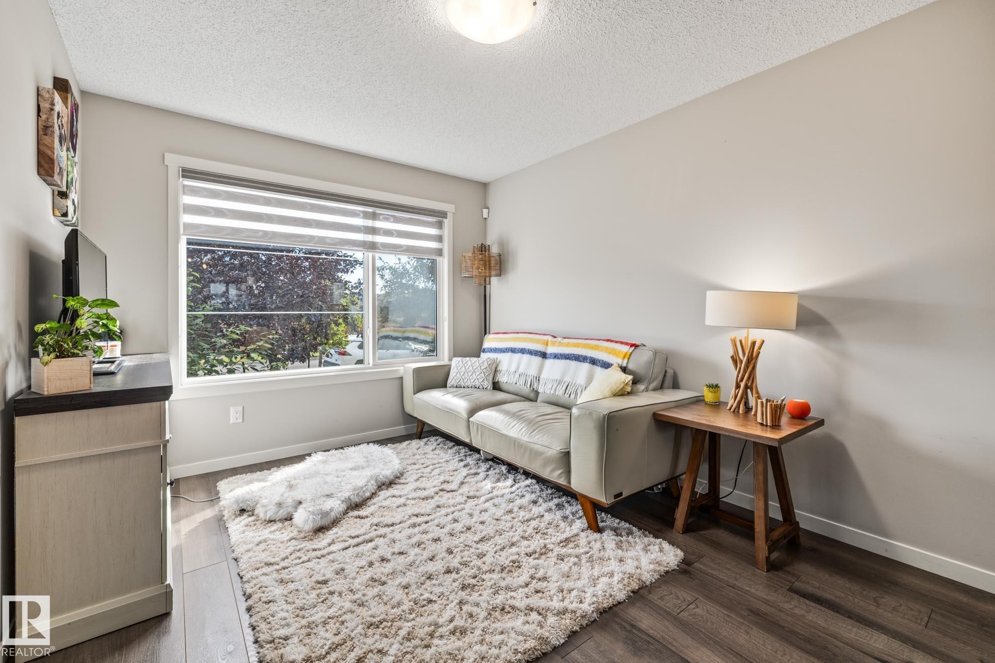 Living room featuring a textured ceiling and wood finished floors - 20110 27 Avenue, Edmonton, AB - Indoor Photo Showing Other Room