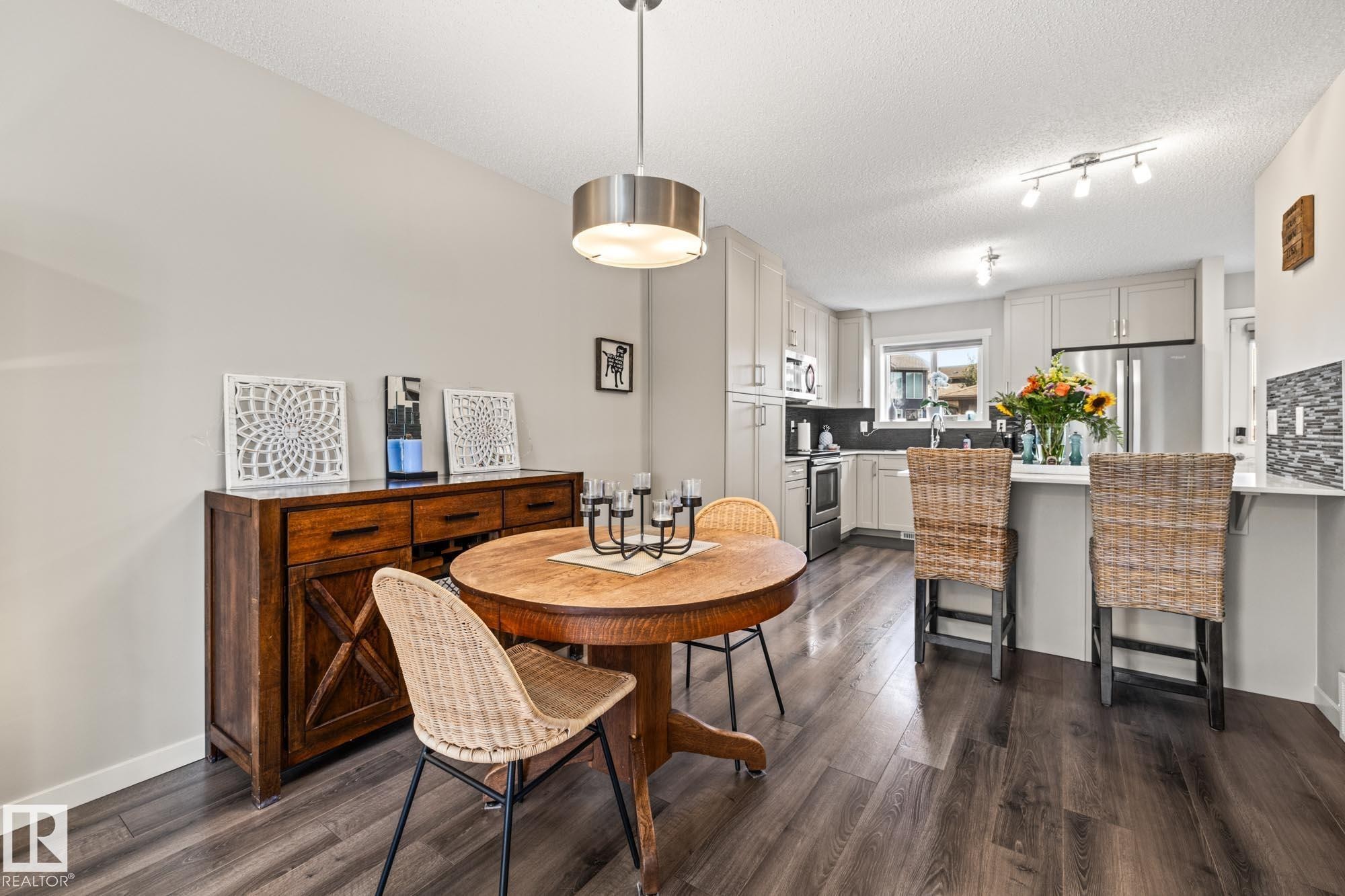 Dining space with dark wood-type flooring and a textured ceiling - 20110 27 Avenue, Edmonton, AB - Indoor Photo Showing Dining Room