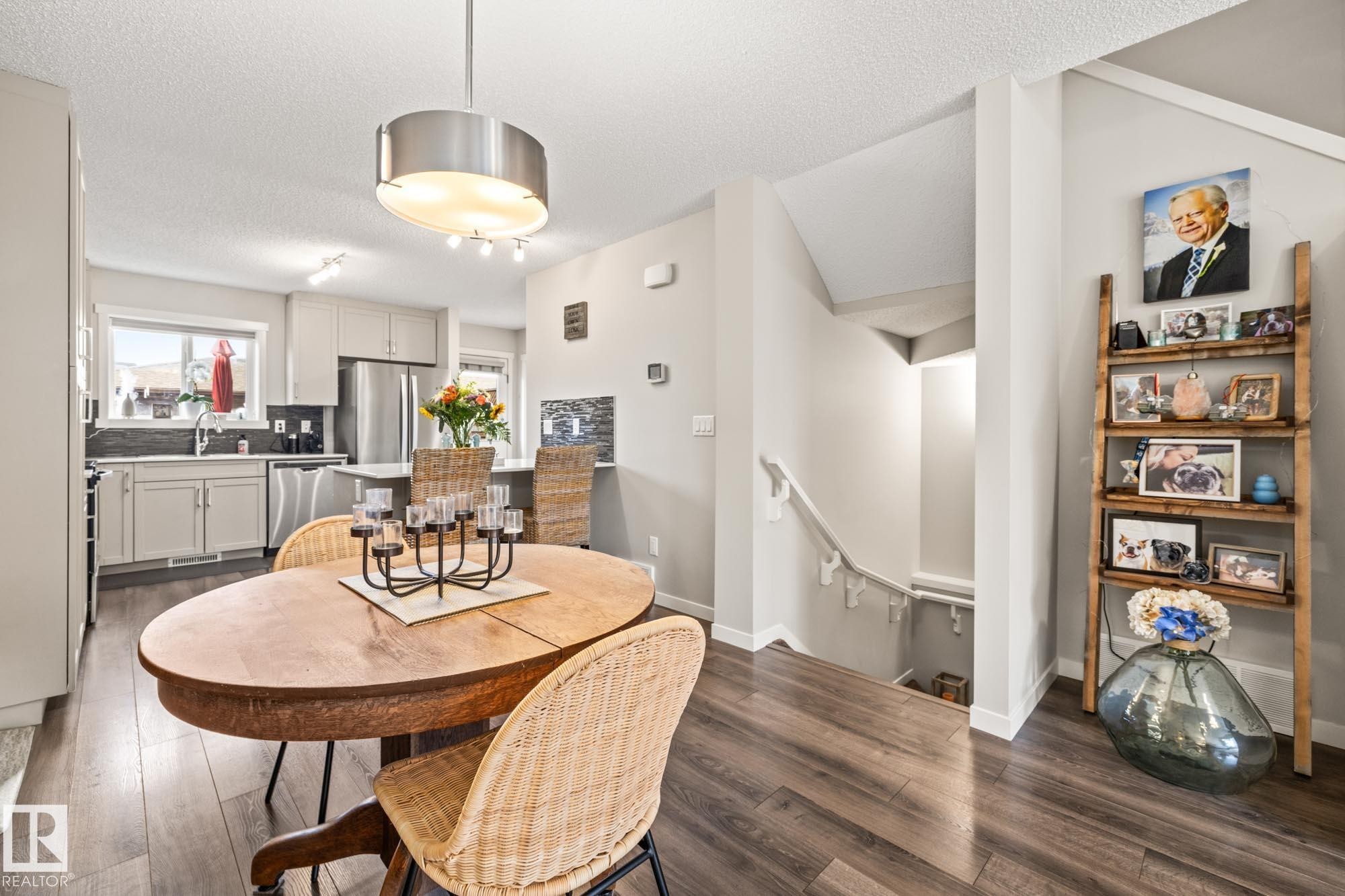 Dining room with dark wood-type flooring and a textured ceiling - 20110 27 Avenue, Edmonton, AB - Indoor Photo Showing Dining Room