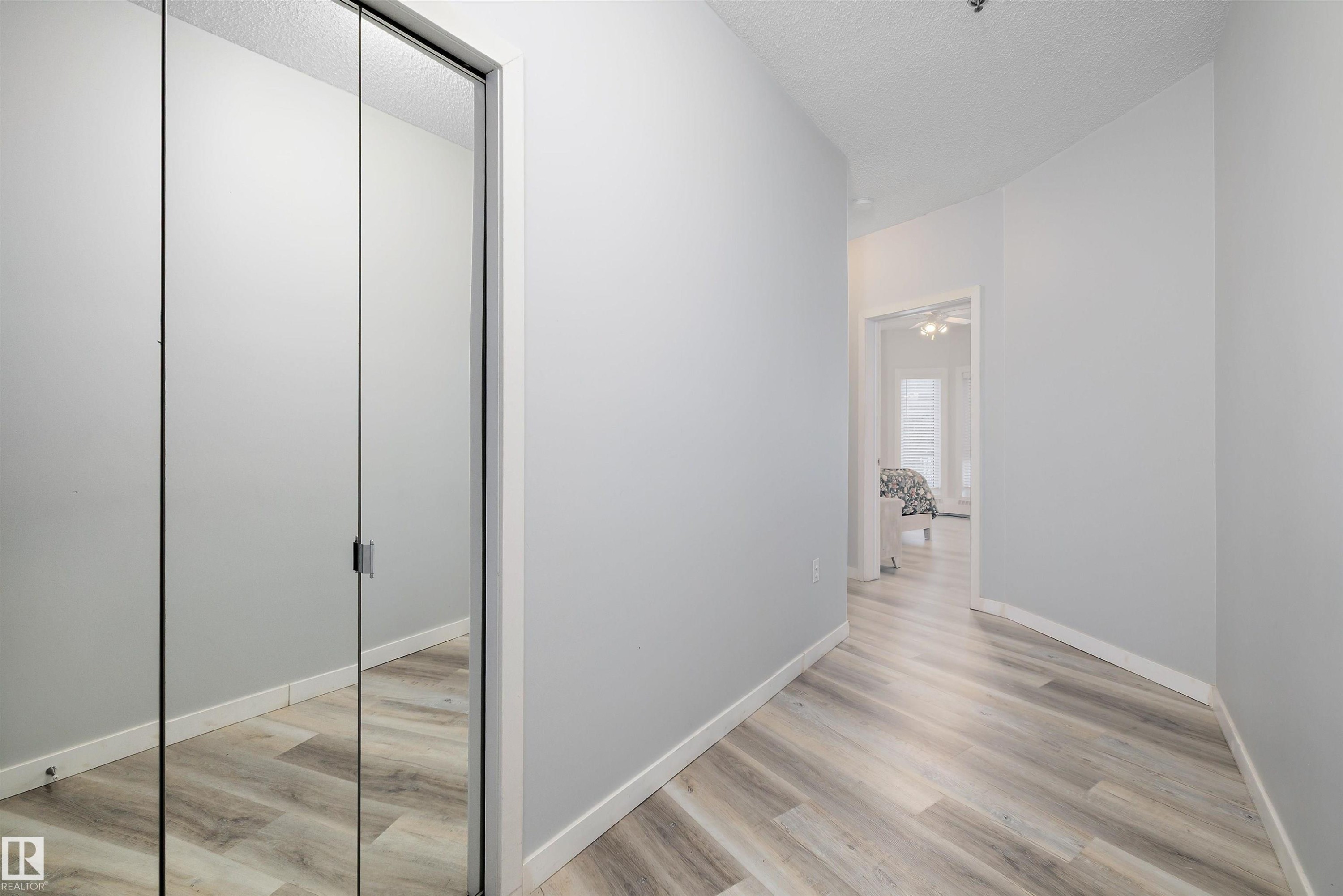 Corridor with light wood-style flooring and a textured ceiling - 205 10809 Saskatchewan Drive, Edmonton, AB - Indoor Photo Showing Other Room