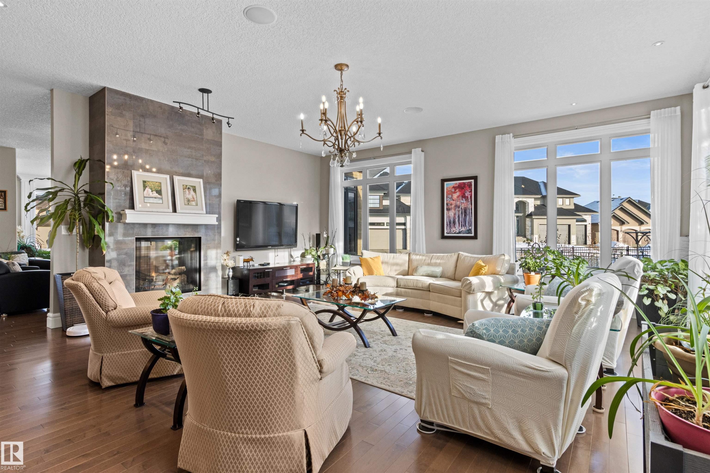 Living room featuring a tile fireplace, dark wood-style flooring, a chandelier, and a textured ceiling - 2796 Wheaton Drive, Edmonton, AB - Indoor Photo Showing Living Room With Fireplace