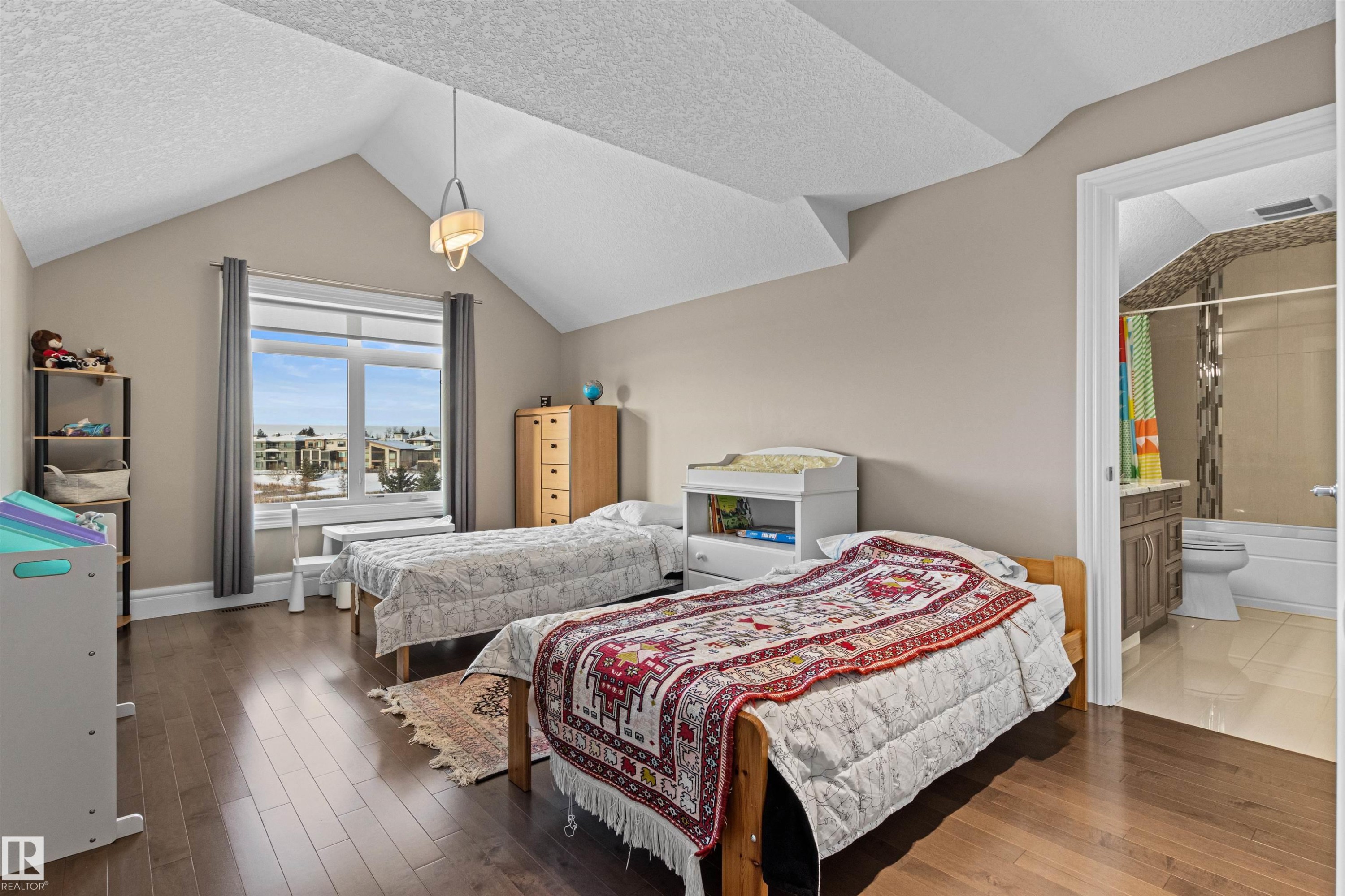 Bedroom with a textured ceiling, vaulted ceiling, wood finished floors, and connected bathroom - 2796 Wheaton Drive, Edmonton, AB - Indoor Photo Showing Bedroom