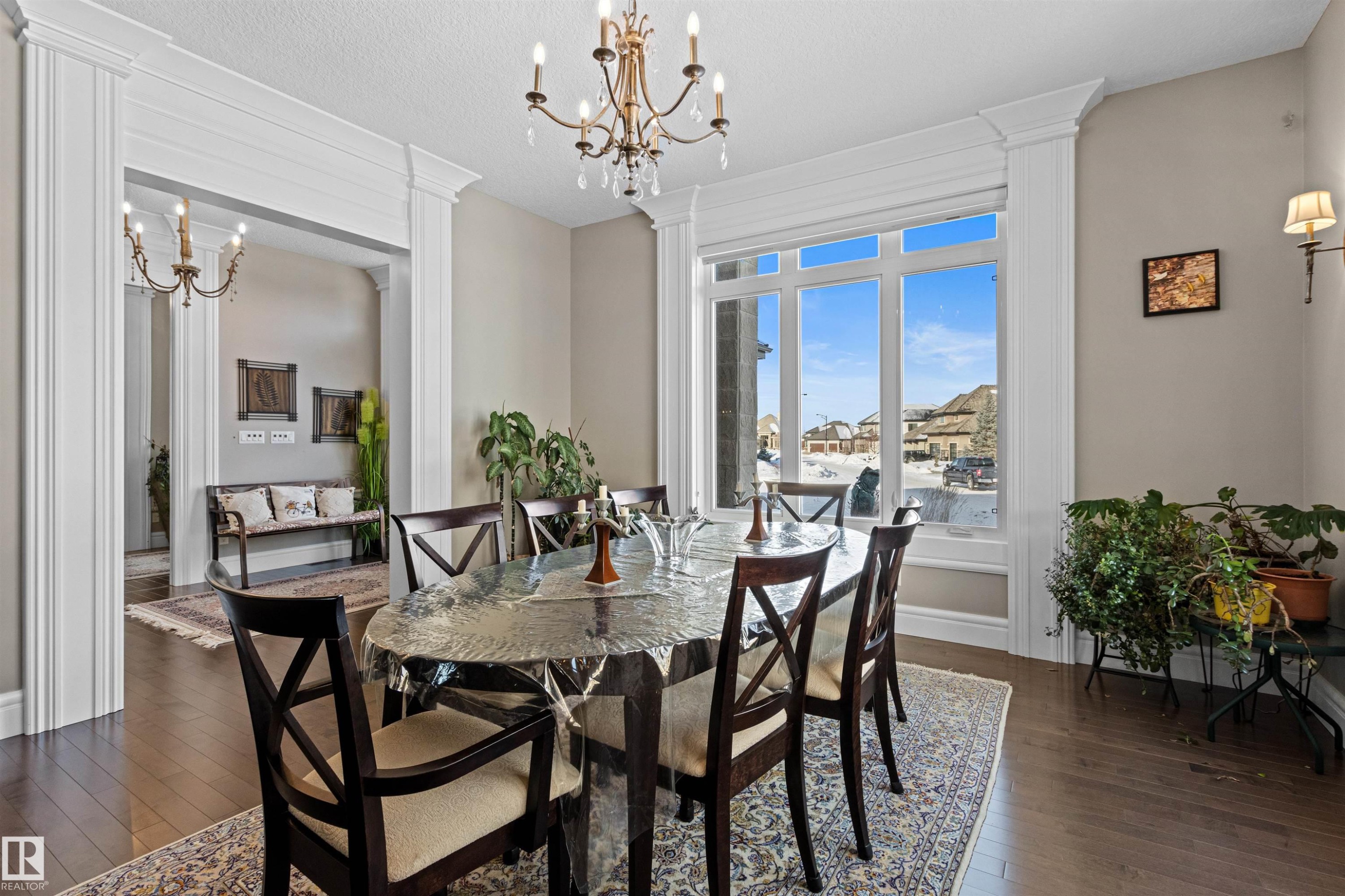 Dining room featuring a chandelier, dark wood finished floors, decorative columns, and a textured ceiling - 2796 Wheaton Drive, Edmonton, AB - Indoor Photo Showing Dining Room