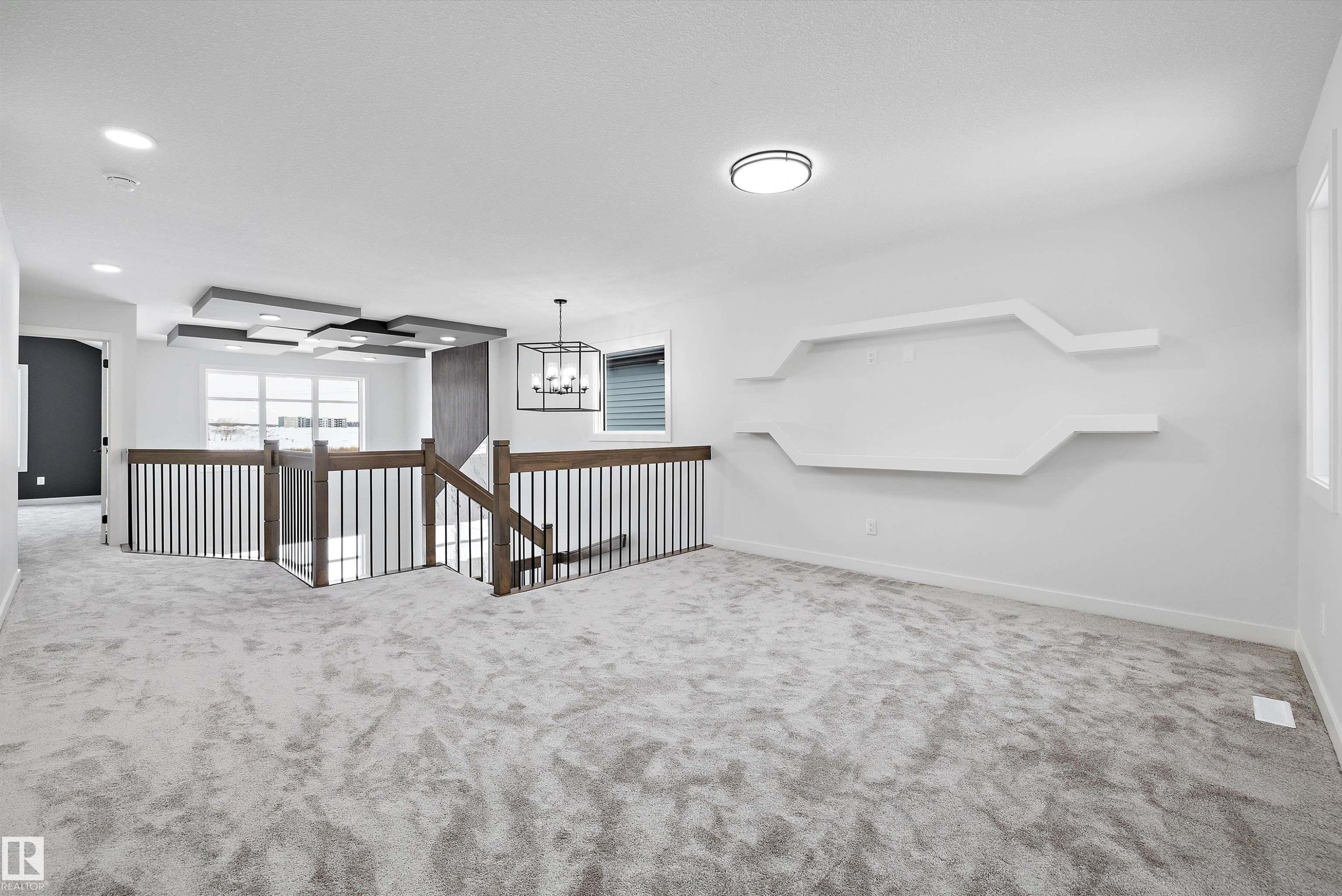 Carpeted spare room featuring baseboards and hanging lights - 230 Edgemont Green Green Nw, Edmonton, AB - Indoor Photo Showing Other Room