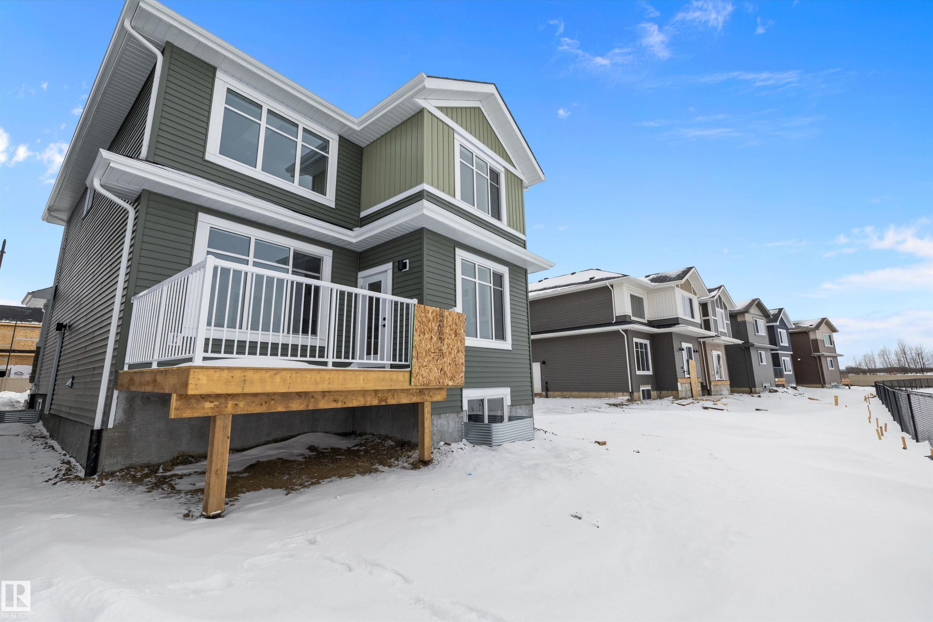 Snow covered back of property featuring a deck and a residential view - 230 Edgemont Green Green Nw, Edmonton, AB - Outdoor With Deck Patio Veranda
