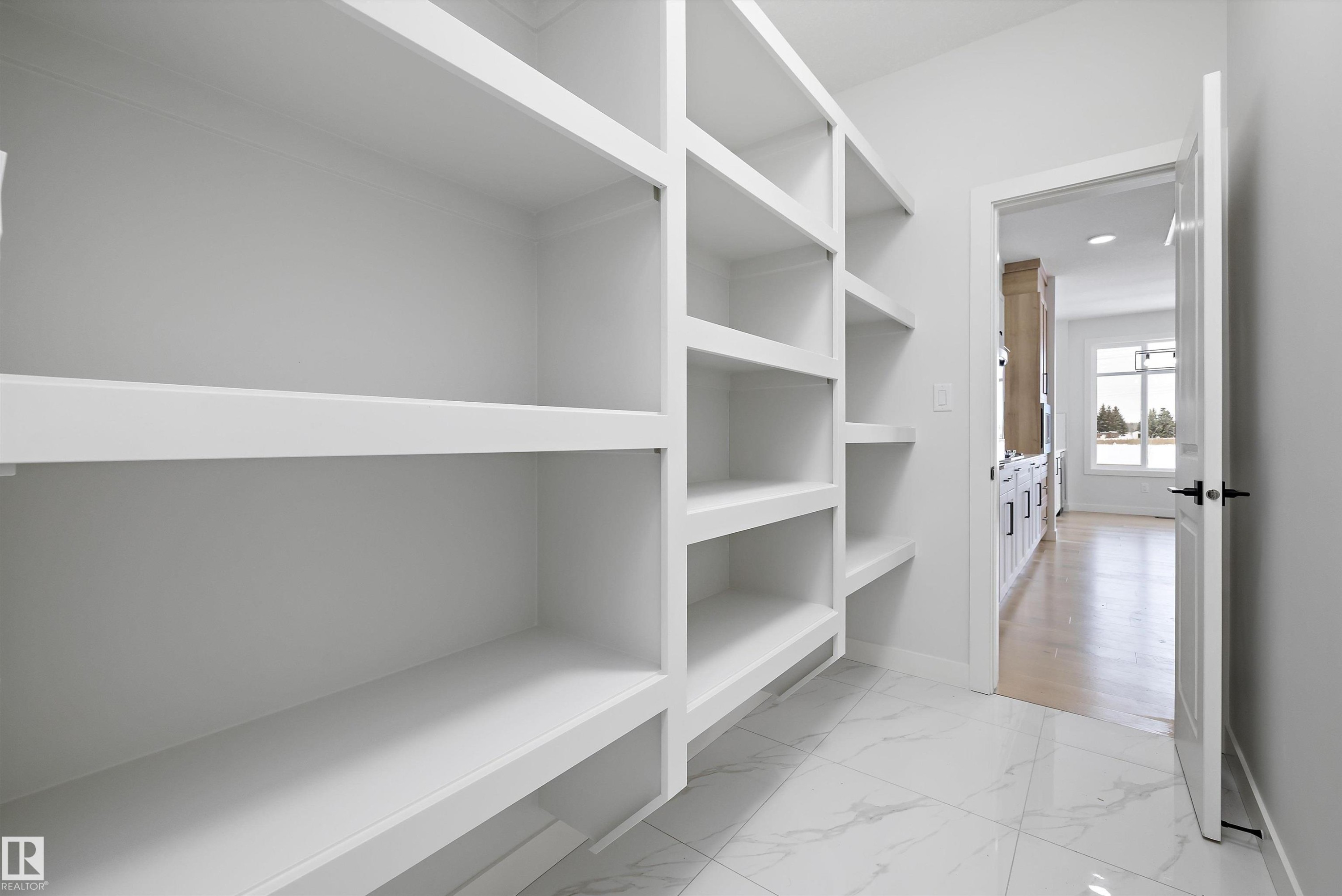 Walk in closet with light marble finish flooring - 230 Edgemont Green Green Nw, Edmonton, AB - Indoor With Storage