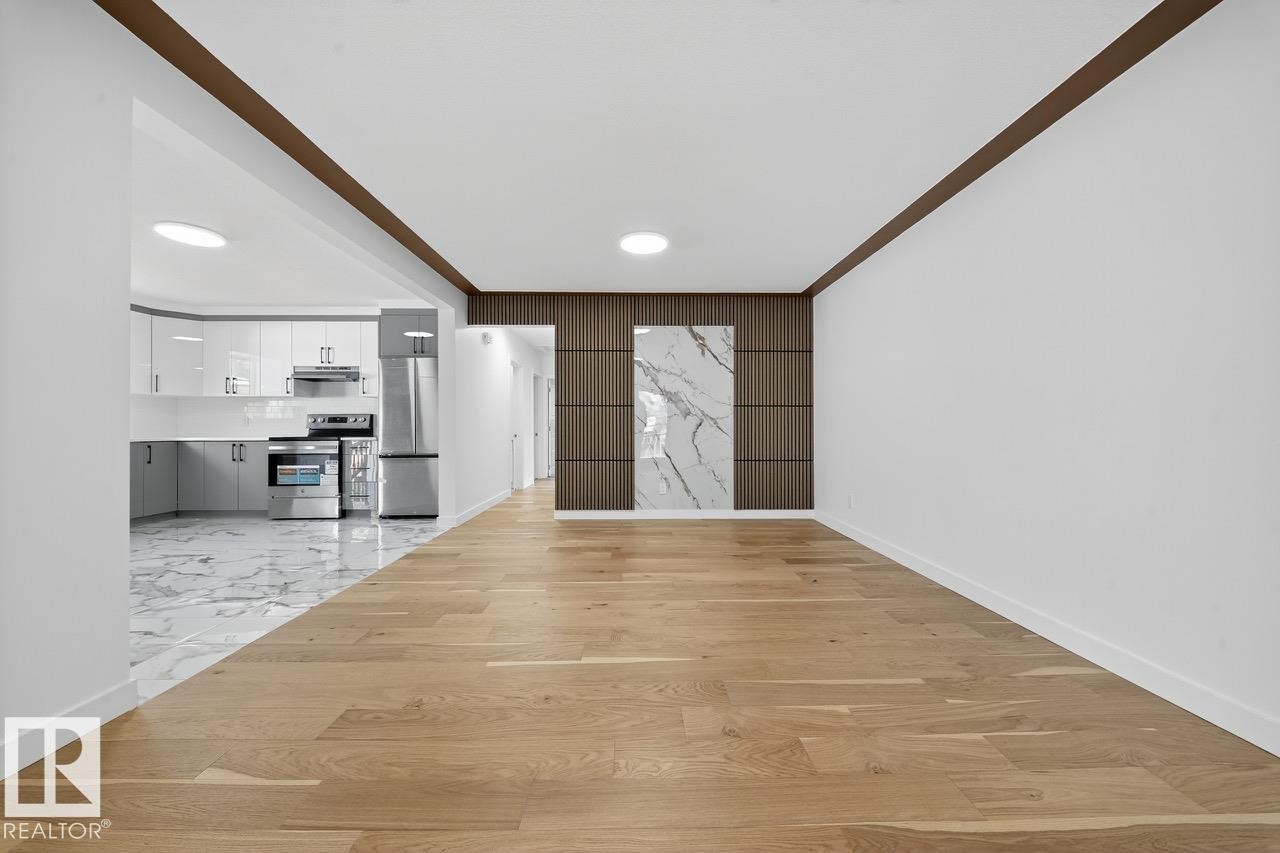 Unfurnished living room featuring light wood-style floors, ornamental molding, and recessed lighting - 12919 113A Street, Edmonton, AB - Indoor Photo Showing Other Room