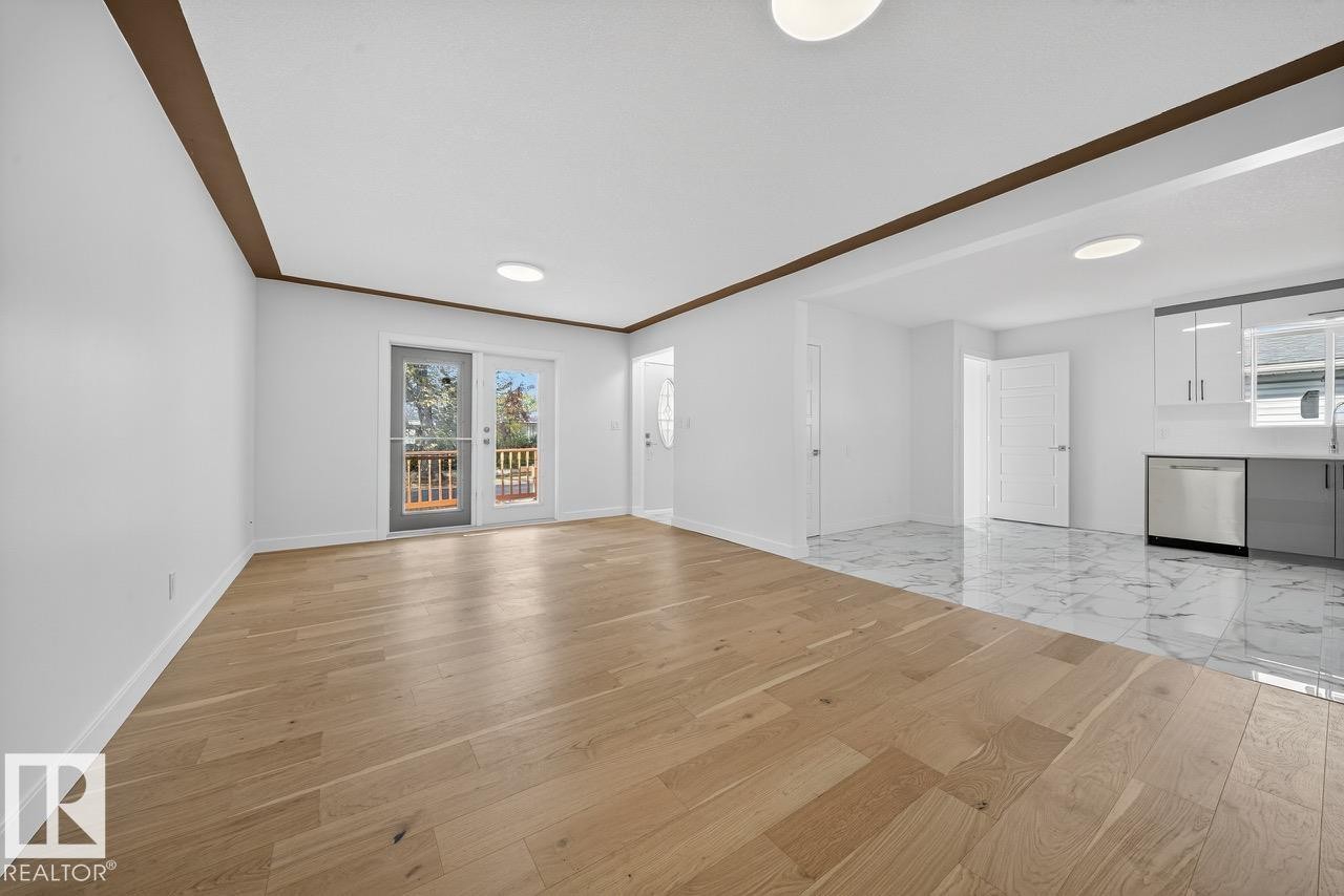Unfurnished living room featuring light wood-type flooring and baseboards - 12919 113A Street, Edmonton, AB - Indoor Photo Showing Other Room