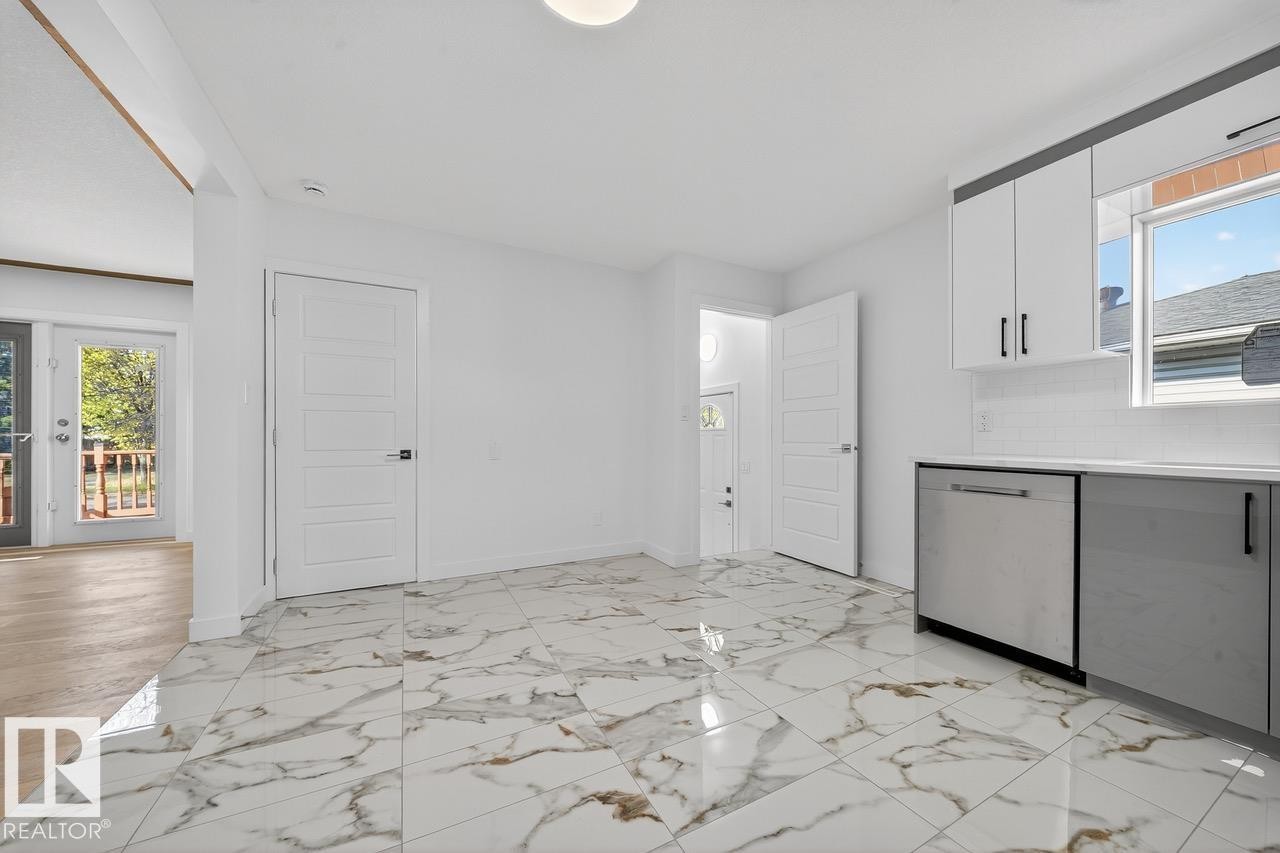 Kitchen featuring healthy amount of natural light, white cabinetry, dishwasher, and backsplash - 12919 113A Street, Edmonton, AB - Indoor