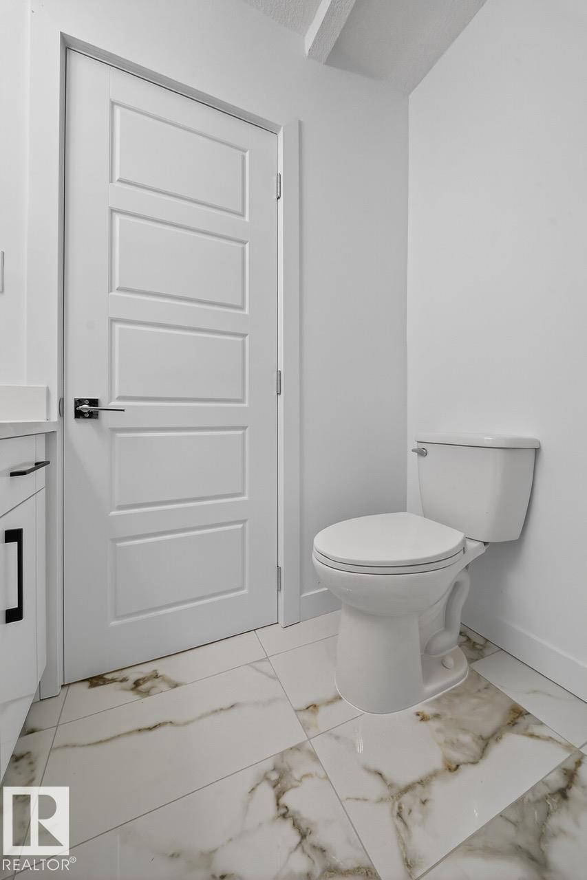 Half bath featuring light marble finish flooring and vanity - 12919 113A Street, Edmonton, AB - Indoor Photo Showing Bathroom