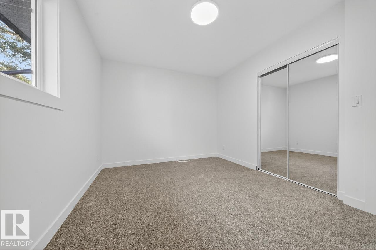 Unfurnished bedroom featuring a closet and light colored carpet - 12919 113A Street, Edmonton, AB - Indoor Photo Showing Other Room
