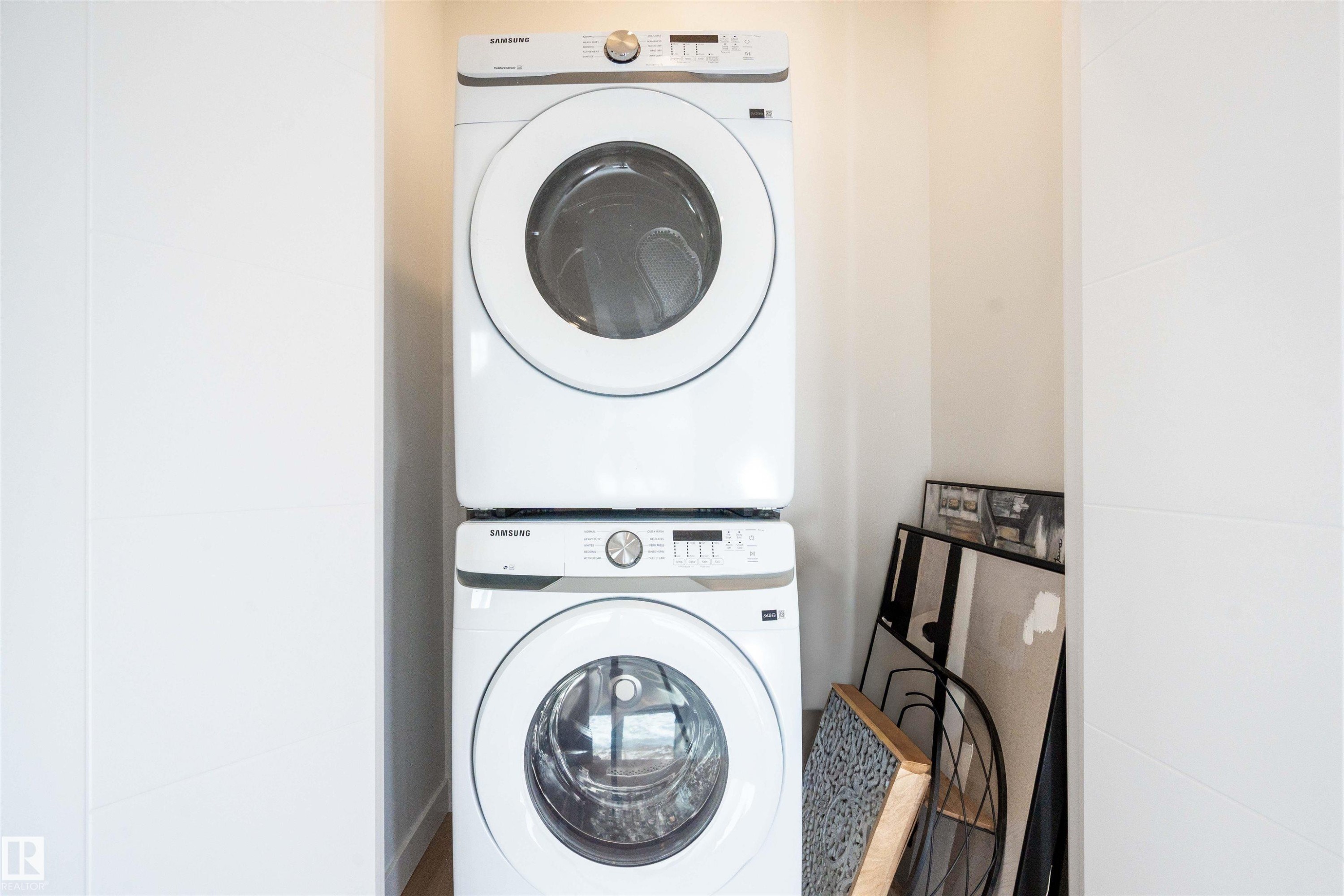 Laundry area with stacked washing machine and dryer - 64 18120 28 Avenue Sw, Edmonton, AB - Indoor Photo Showing Laundry Room