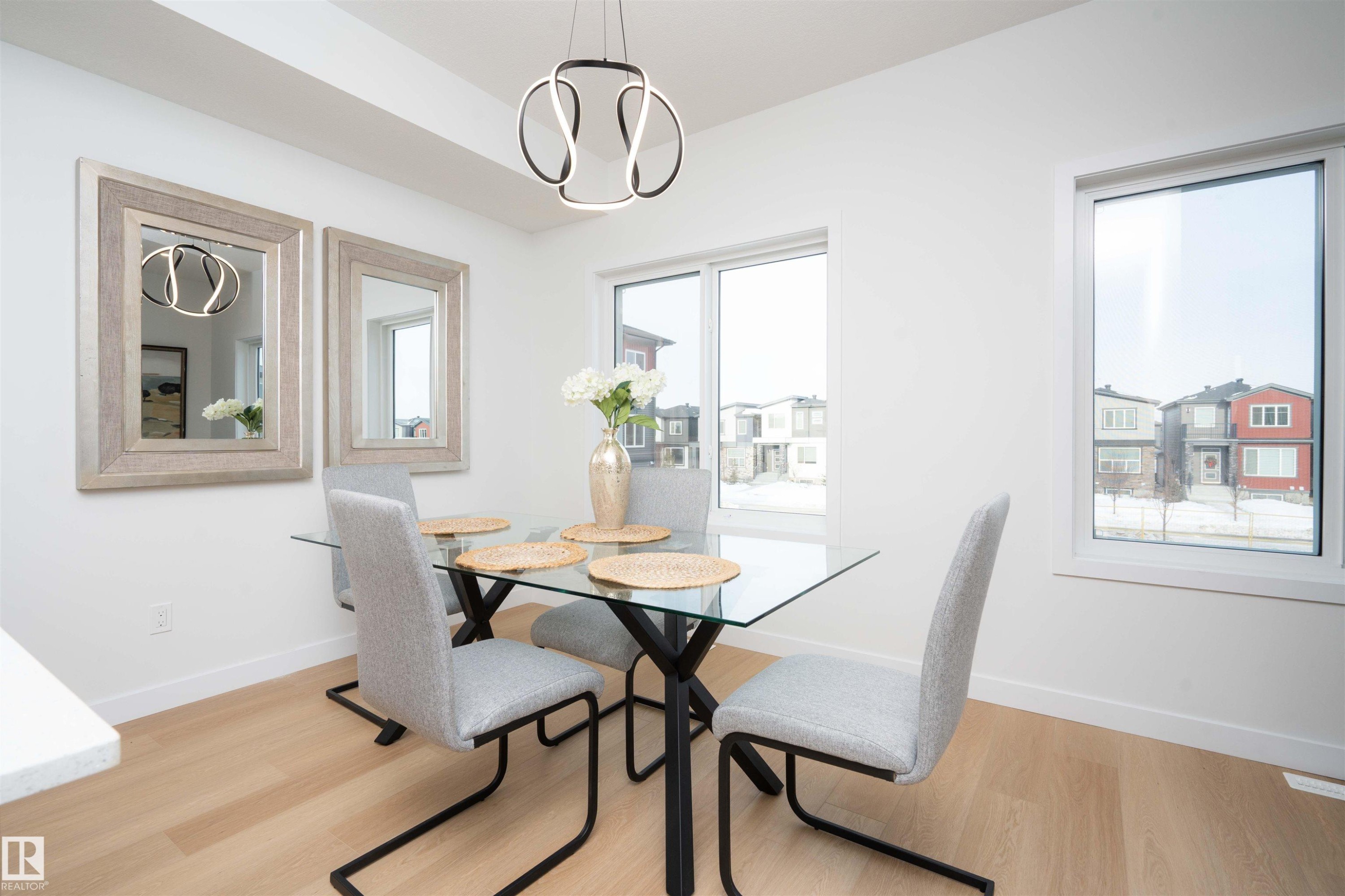 Dining area featuring light wood-type flooring and a chandelier - 64 18120 28 Avenue Sw, Edmonton, AB - Indoor Photo Showing Dining Room