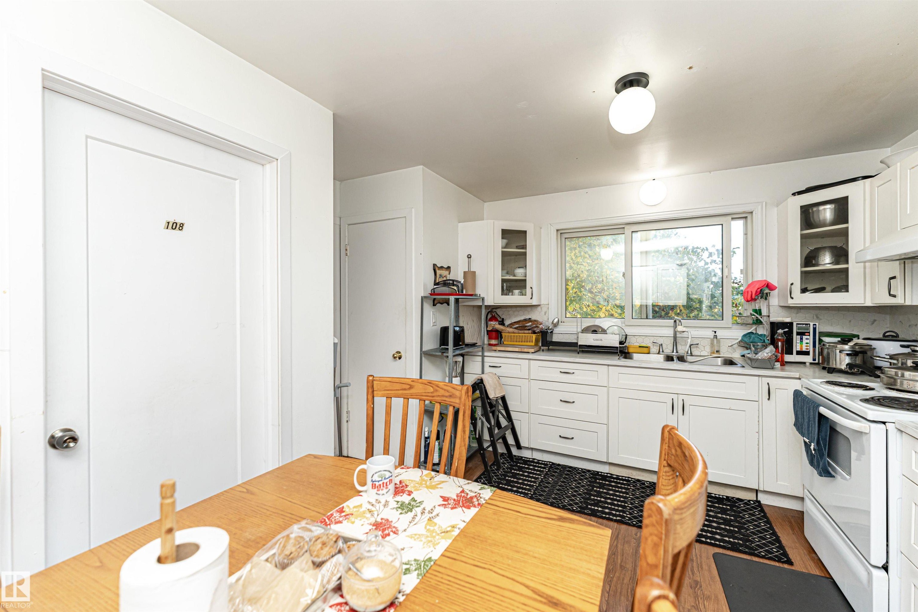 Kitchen with glass insert cabinets, white cabinets, and white electric range oven - 2349 Millbourne Road W, Edmonton, AB - Indoor