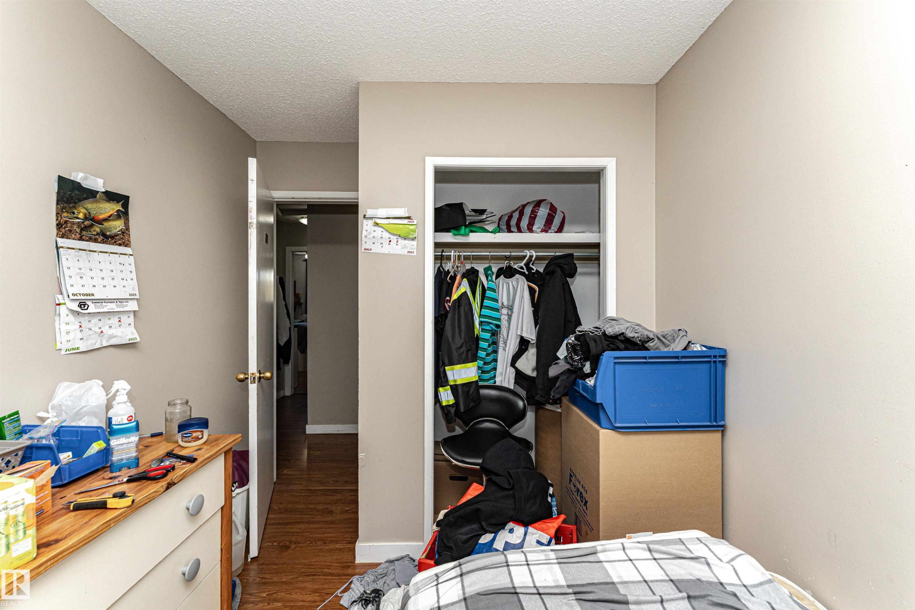 Bedroom featuring wood finished floors, a textured ceiling, and a closet - 2349 Millbourne Road W, Edmonton, AB - Indoor