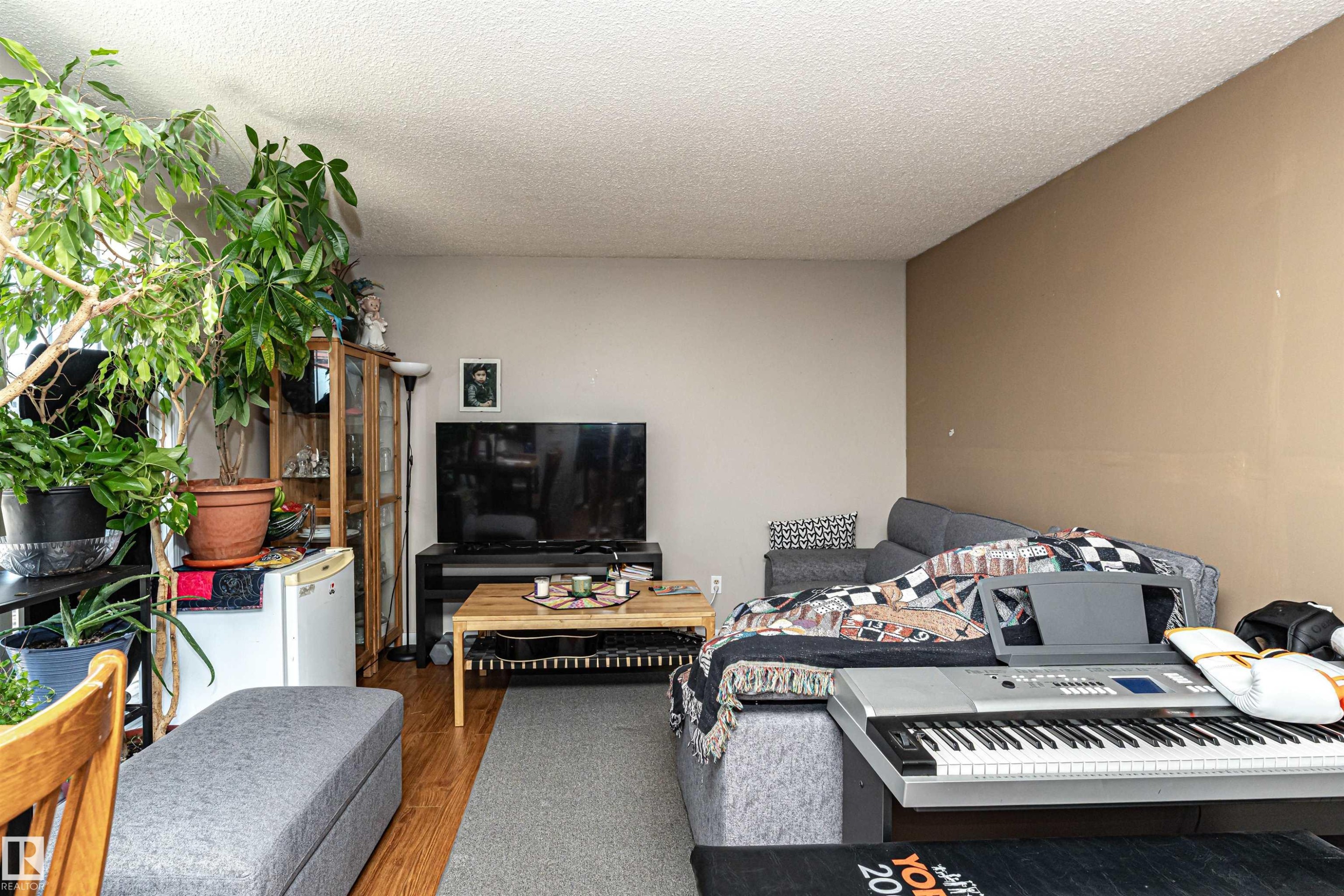 Living room with wood finished floors and a textured ceiling - 2349 Millbourne Road W, Edmonton, AB - Indoor