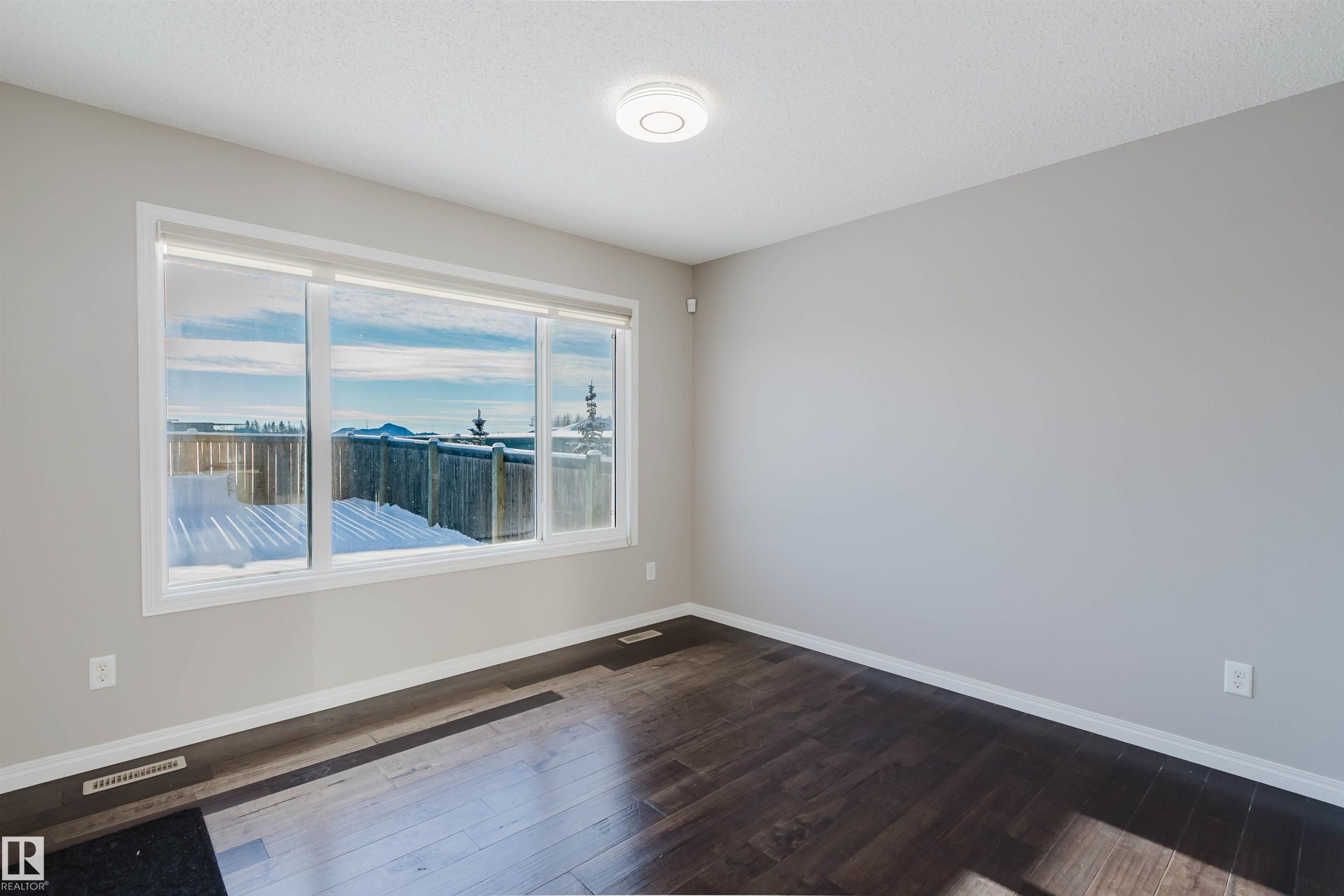 Empty room with baseboards and dark wood finished floors - 16627 18 Avenue, Edmonton, AB - Indoor Photo Showing Other Room
