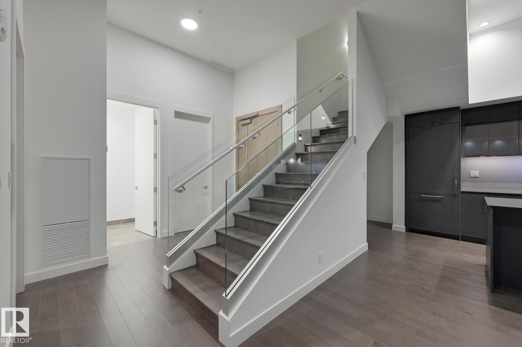 Stairway with wood finished floors, a towering ceiling, and recessed lighting - 2303 10360 102 Street, Edmonton, AB - Indoor
