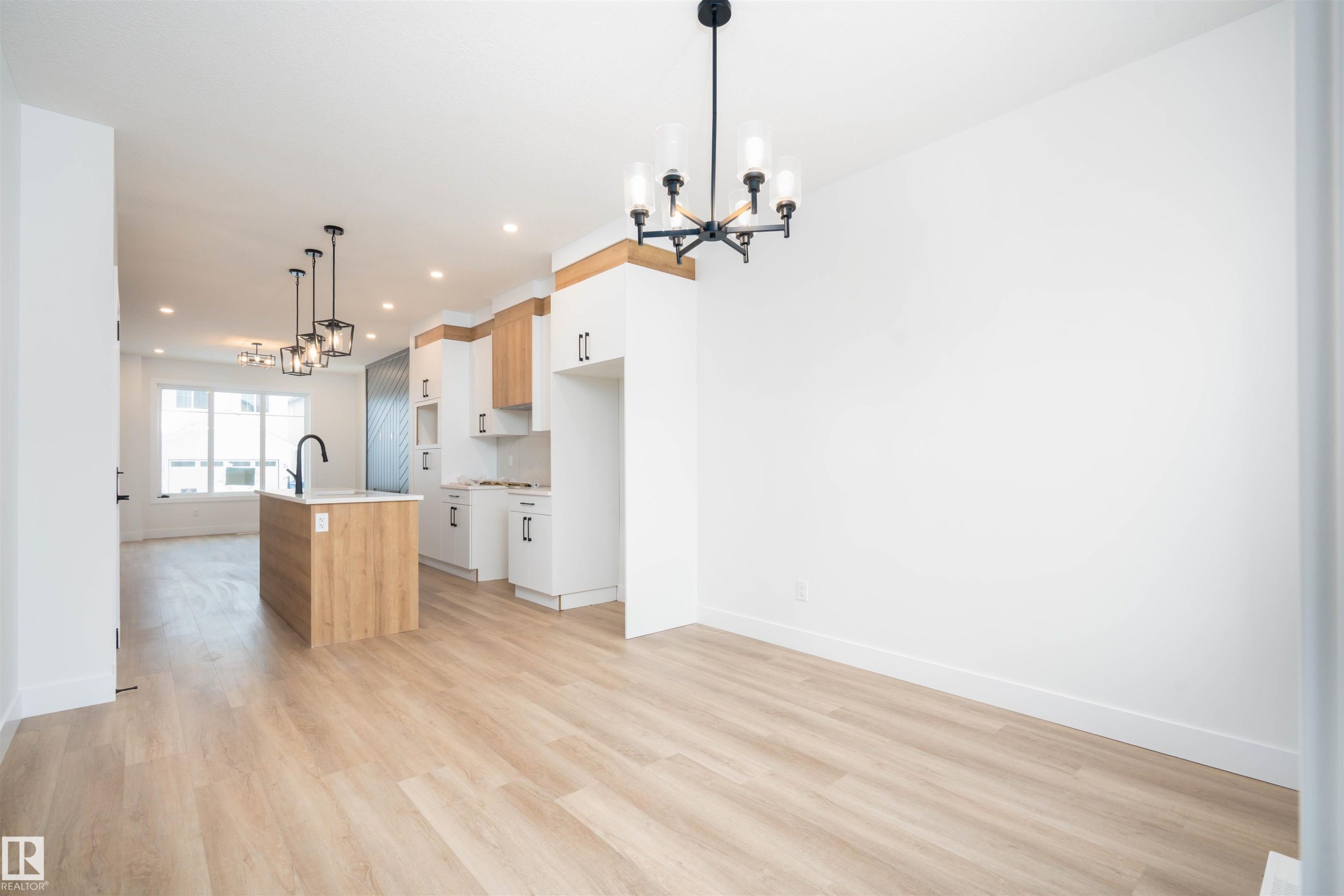 Kitchen featuring a chandelier, decorative light fixtures, an island with sink, open floor plan, and recessed lighting - 430 Crystal Creek Link, Leduc, AB - Indoor Photo Showing Kitchen