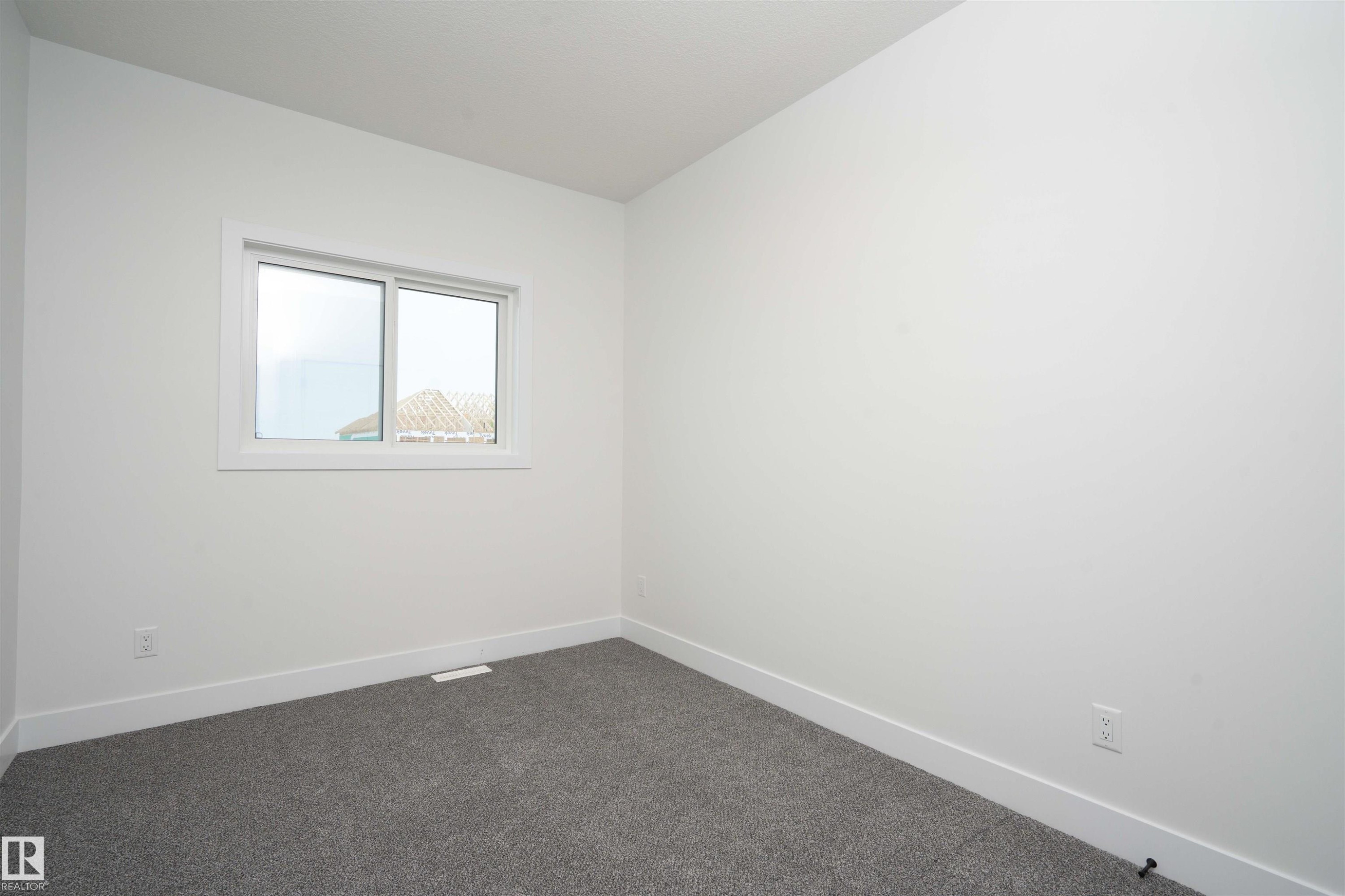 Spare room featuring baseboards and dark colored carpet - 430 Crystal Creek Link, Leduc, AB - Indoor Photo Showing Other Room