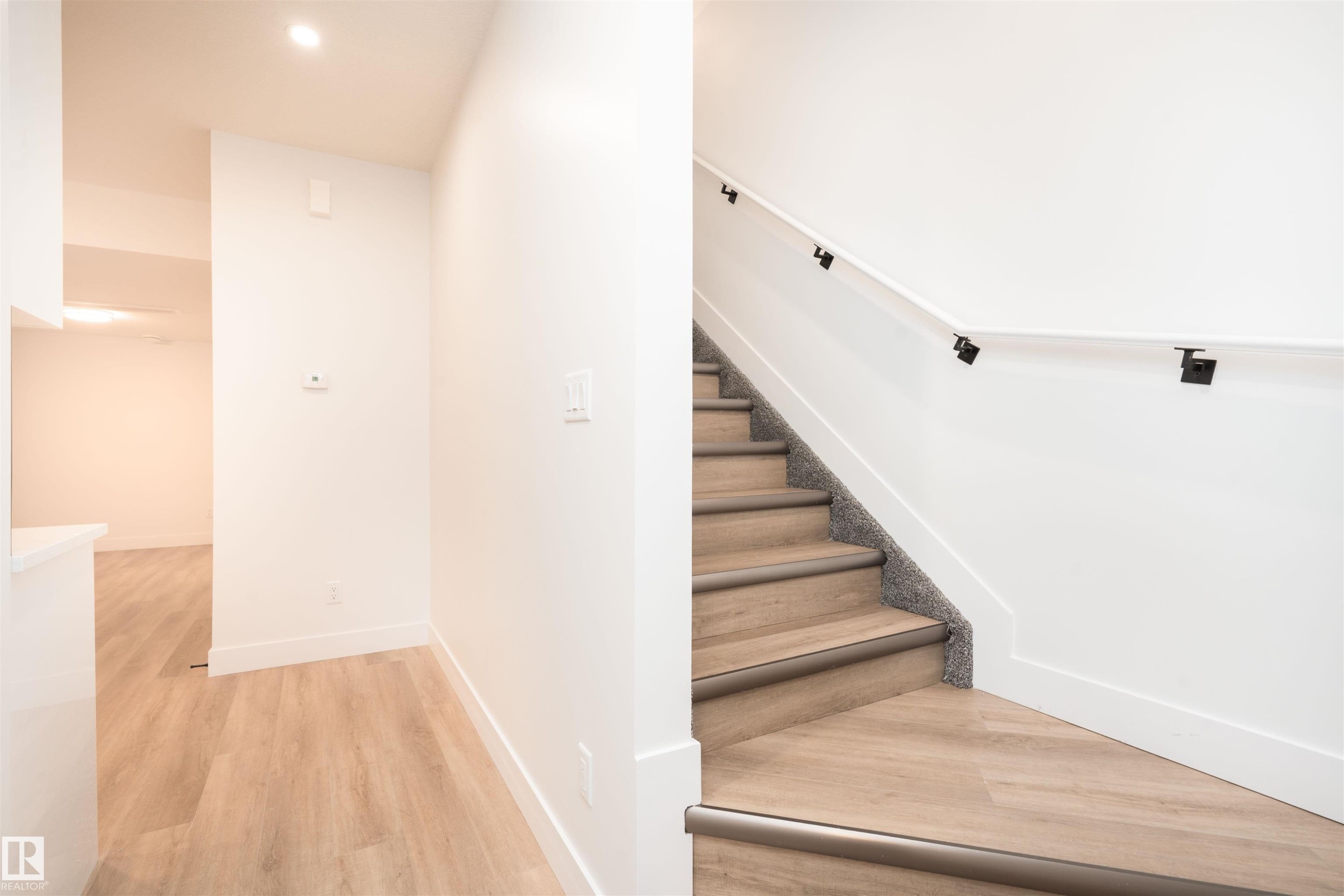 Stairs with wood finished floors and recessed lighting - 430 Crystal Creek Link, Leduc, AB - Indoor Photo Showing Other Room