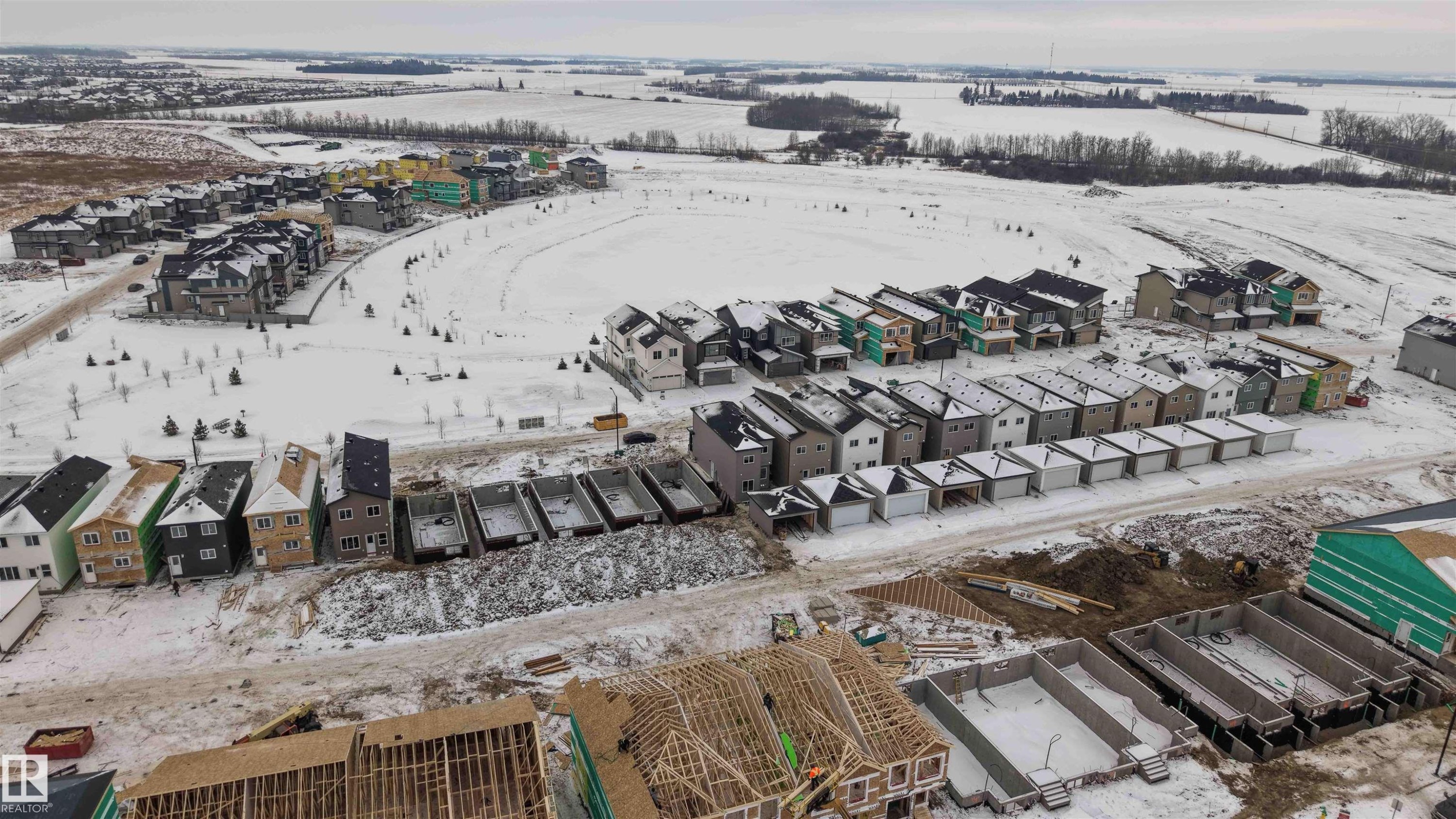Snowy aerial view featuring a residential view - 430 Crystal Creek Link, Leduc, AB - Outdoor With View