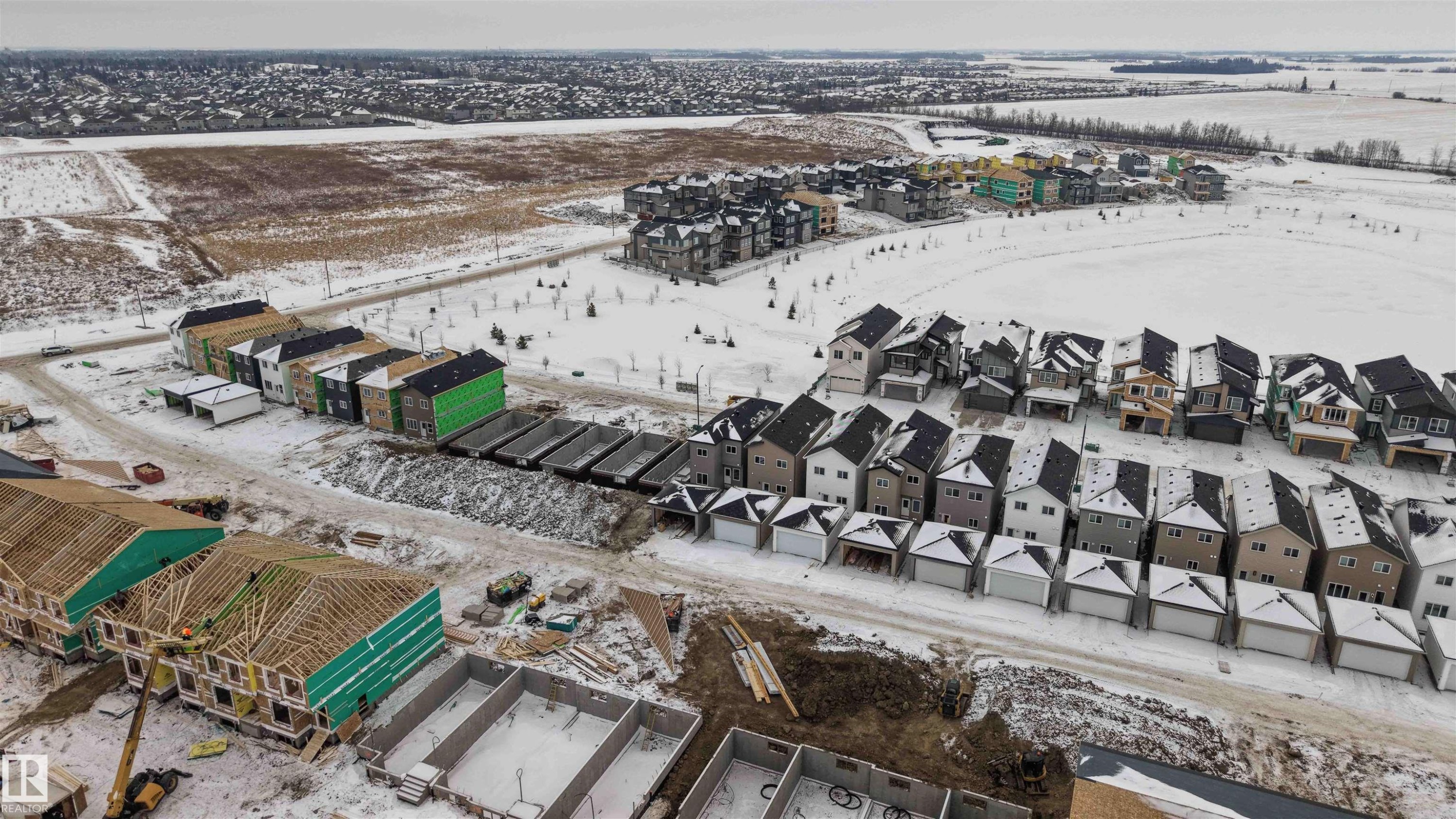 Snowy aerial view featuring a residential view - 430 Crystal Creek Link, Leduc, AB - Outdoor With View