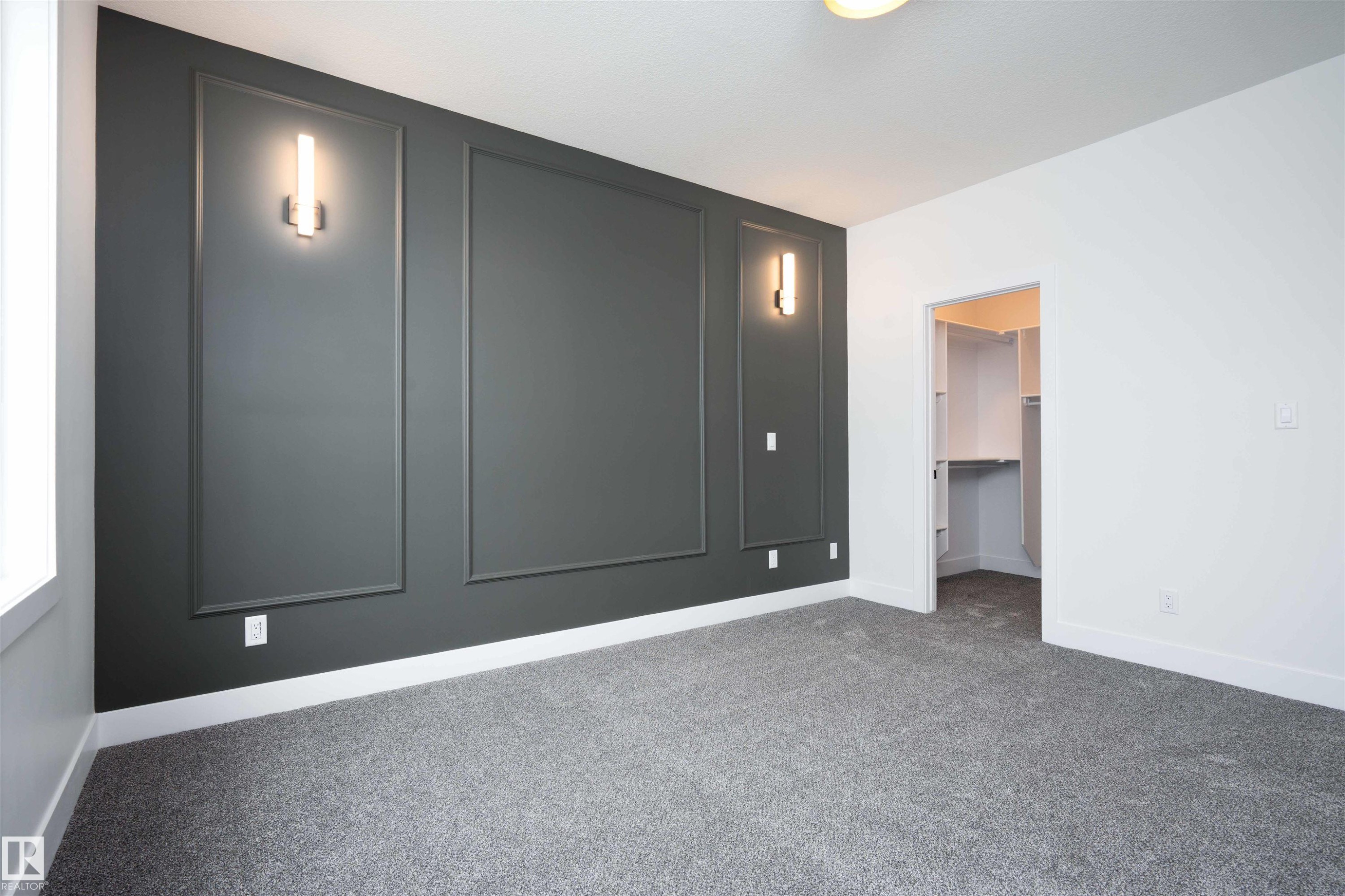 Unfurnished bedroom with a walk in closet, carpet flooring, and a decorative wall - 430 Crystal Creek Link, Leduc, AB - Indoor Photo Showing Other Room