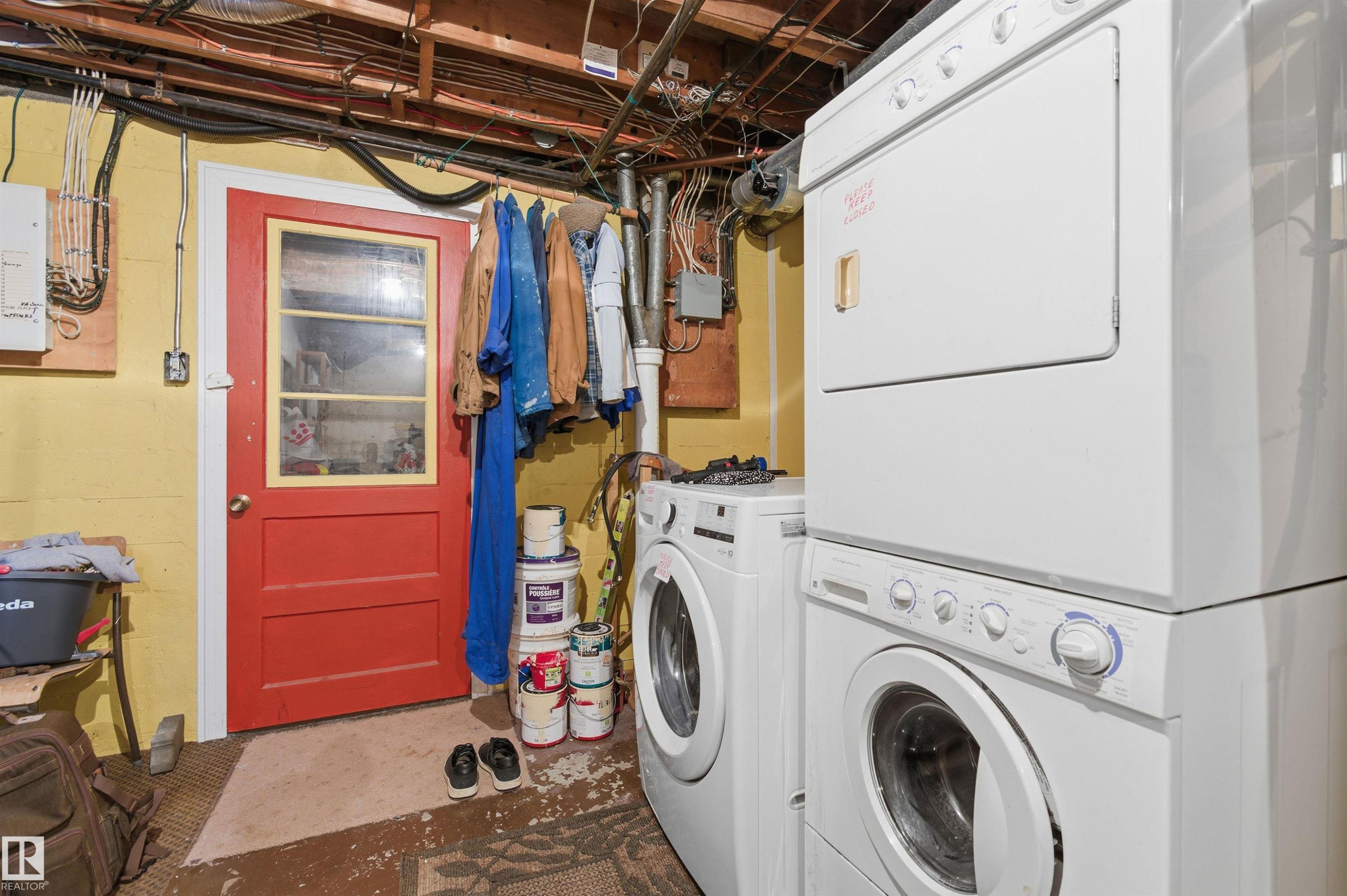 Washroom featuring concrete flooring and stacked washing machine and dryer - 10332 82 Street, Edmonton, AB - Indoor Photo Showing Laundry Room