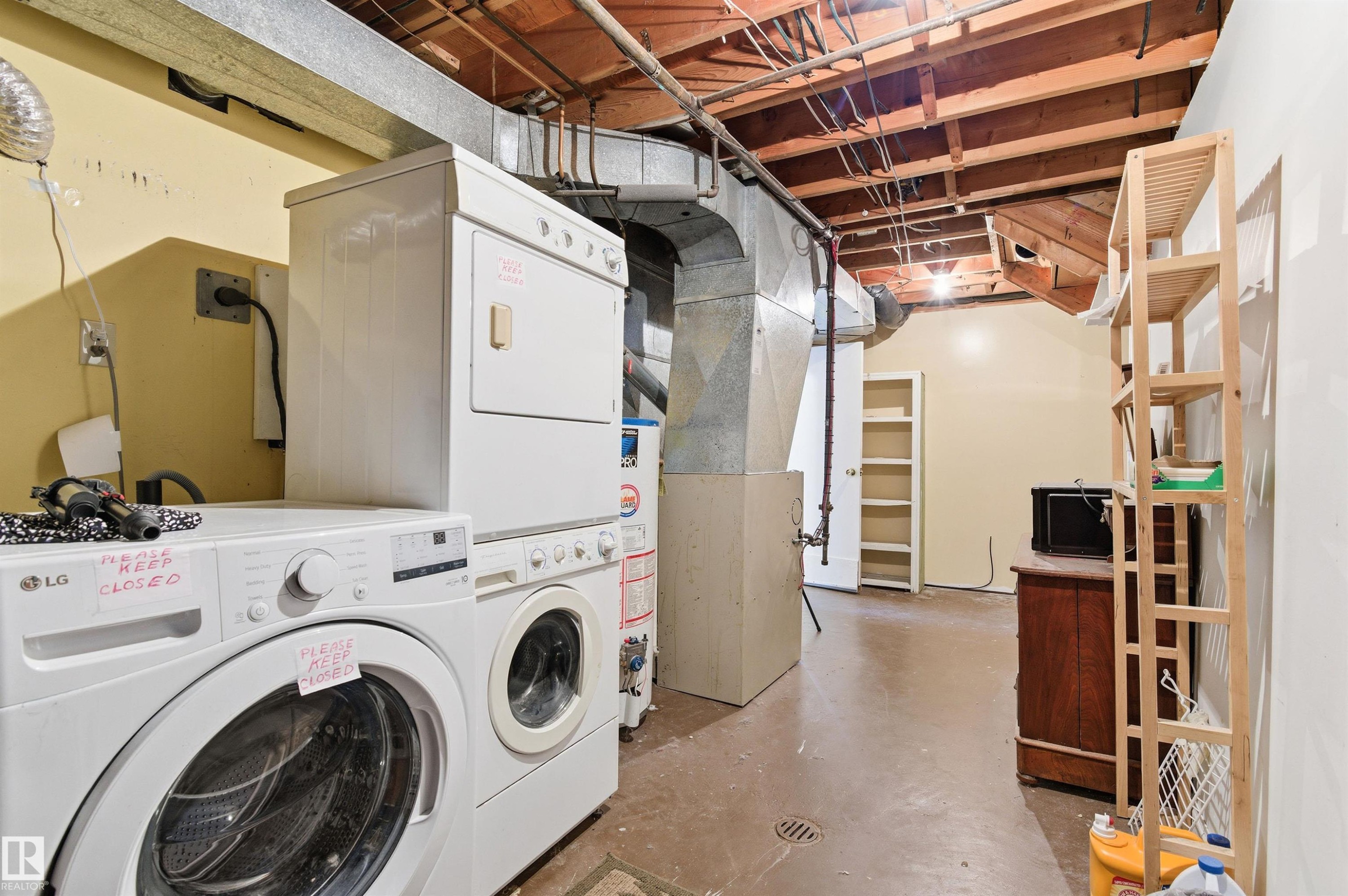 Laundry room featuring concrete floors, water heater, and electric dryer hookup - 10332 82 Street, Edmonton, AB - Indoor Photo Showing Laundry Room