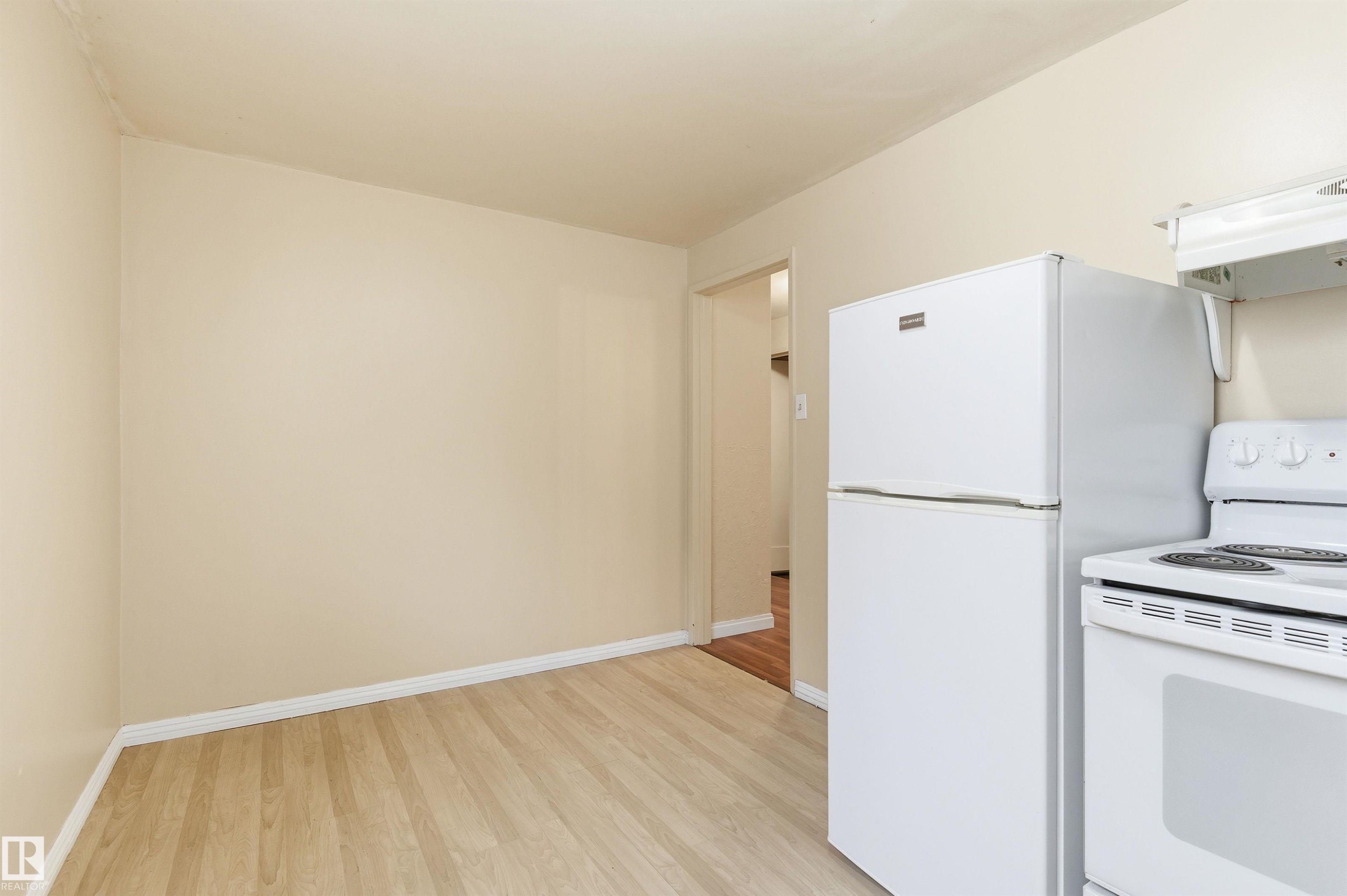 Kitchen with white appliances, light wood-style floors, and under cabinet range hood - 10332 82 Street, Edmonton, AB - Indoor Photo Showing Kitchen