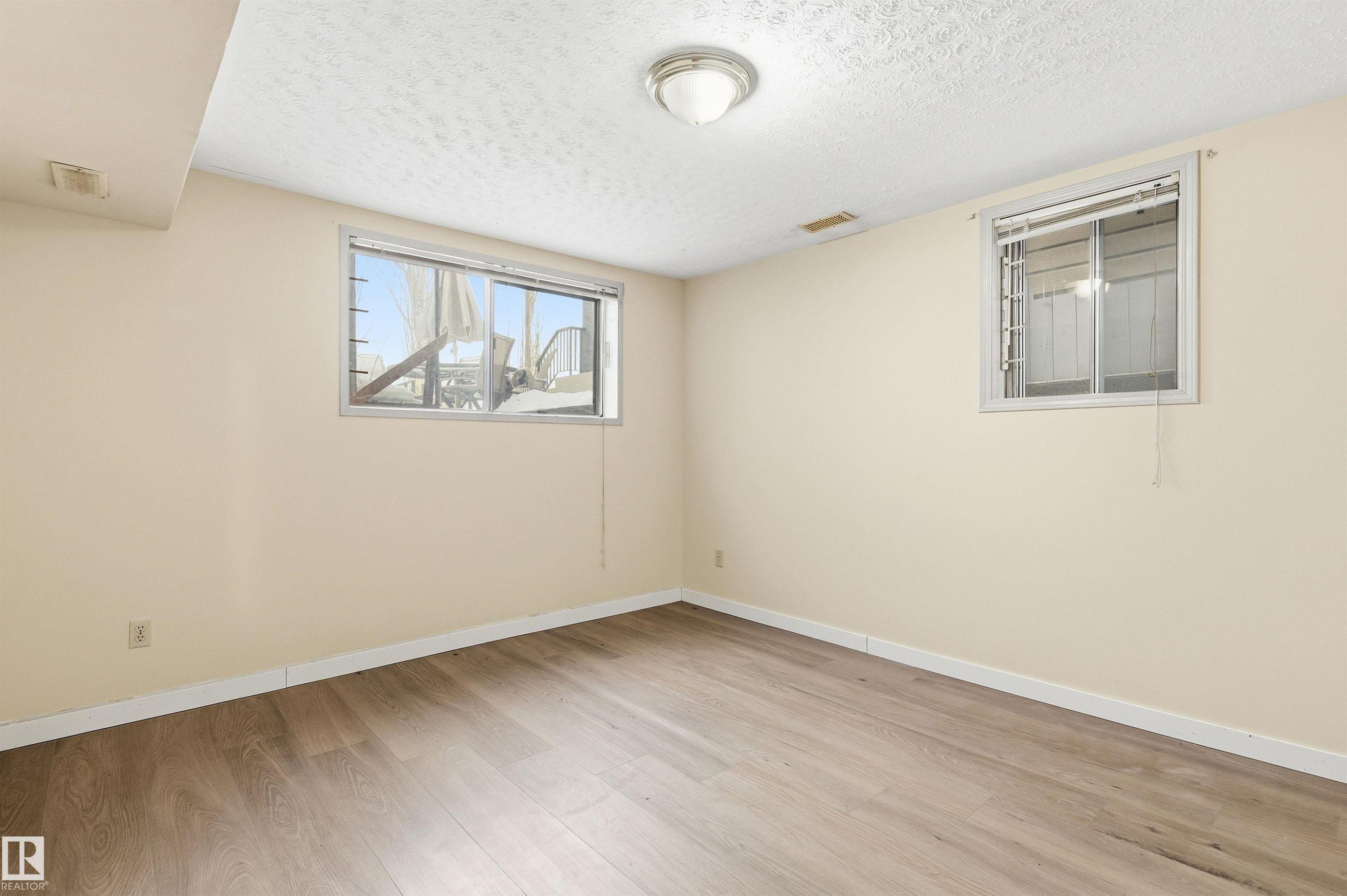 Spare room with light wood-type flooring and a textured ceiling - 10332 82 Street, Edmonton, AB - Indoor Photo Showing Other Room