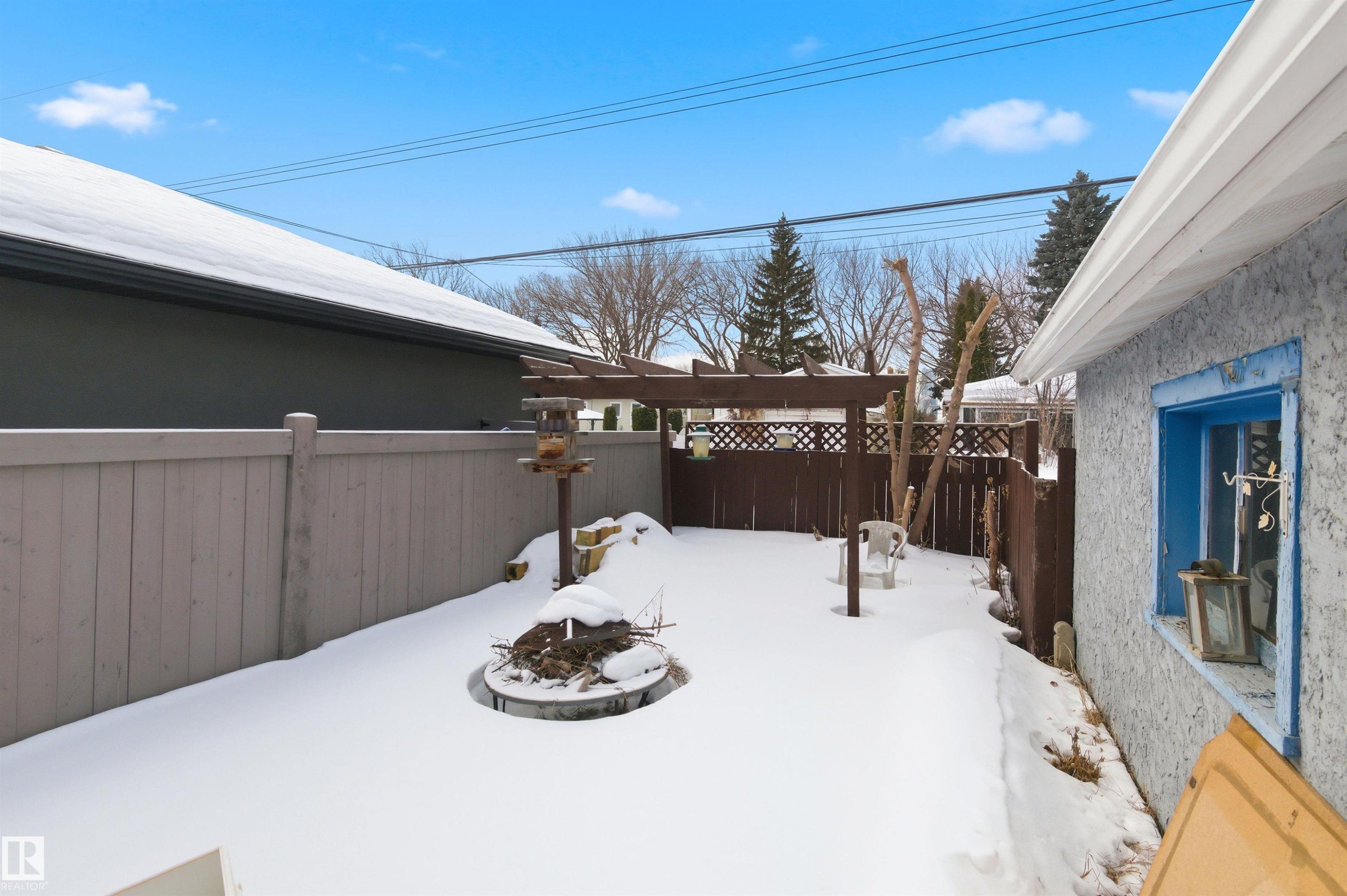 Yard covered in snow featuring a fire pit and a fenced backyard - 10332 82 Street, Edmonton, AB - Outdoor